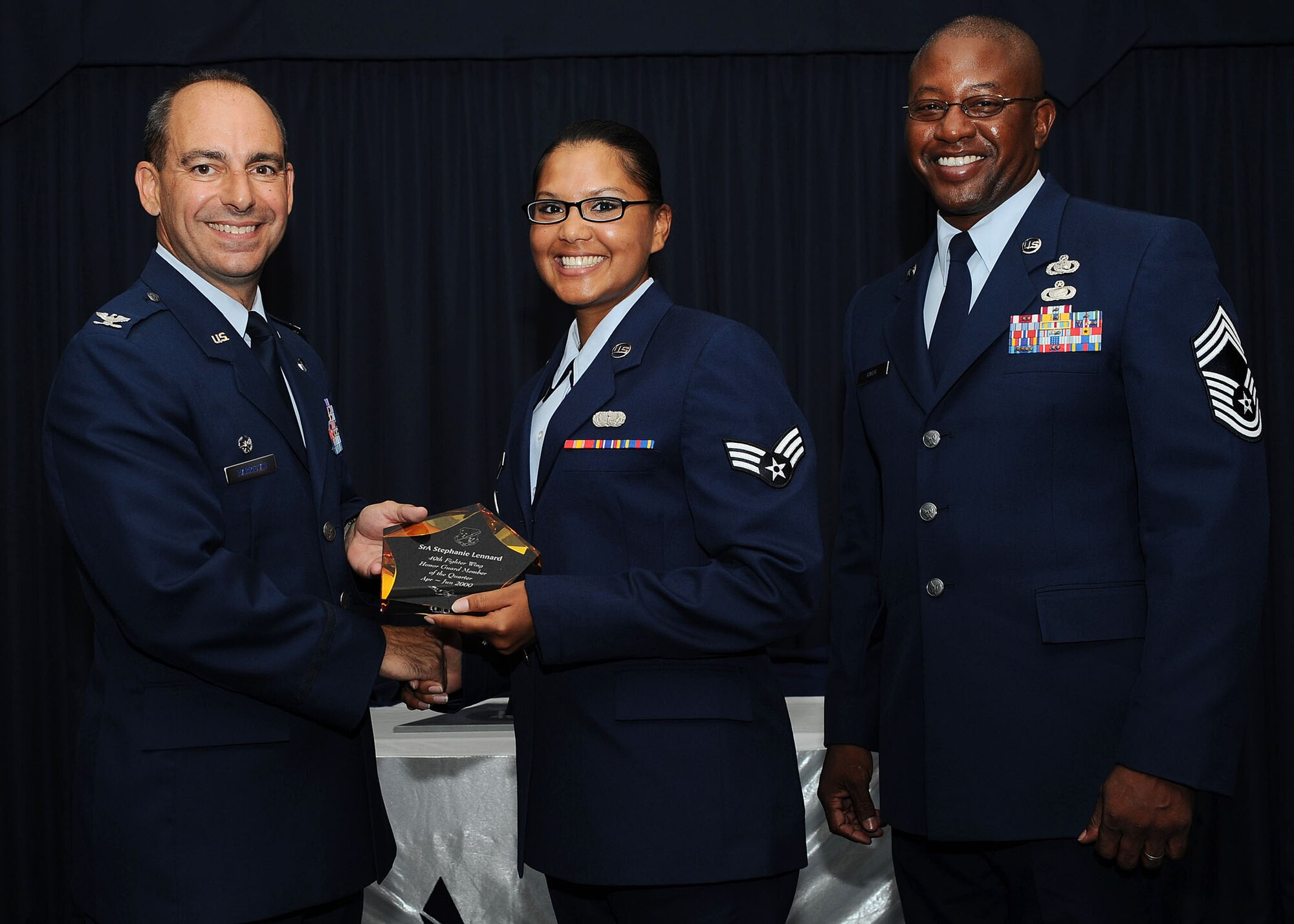 Col. Jeff Harrigian, 49th Fighter Wing commander, and Chief Master Sgt. Jerome Baker, 49th Mission Support Group, present the award for Wing honor guard member of the quarter to Senior Airman Stephanie Lennard, 49th Steel Talons Honor Guard, at Holloman Air Force Base, N.M., July 16.  The 49th Fighter Wing Quarterly Awards recognized the hard work of the 2nd quarter winners.