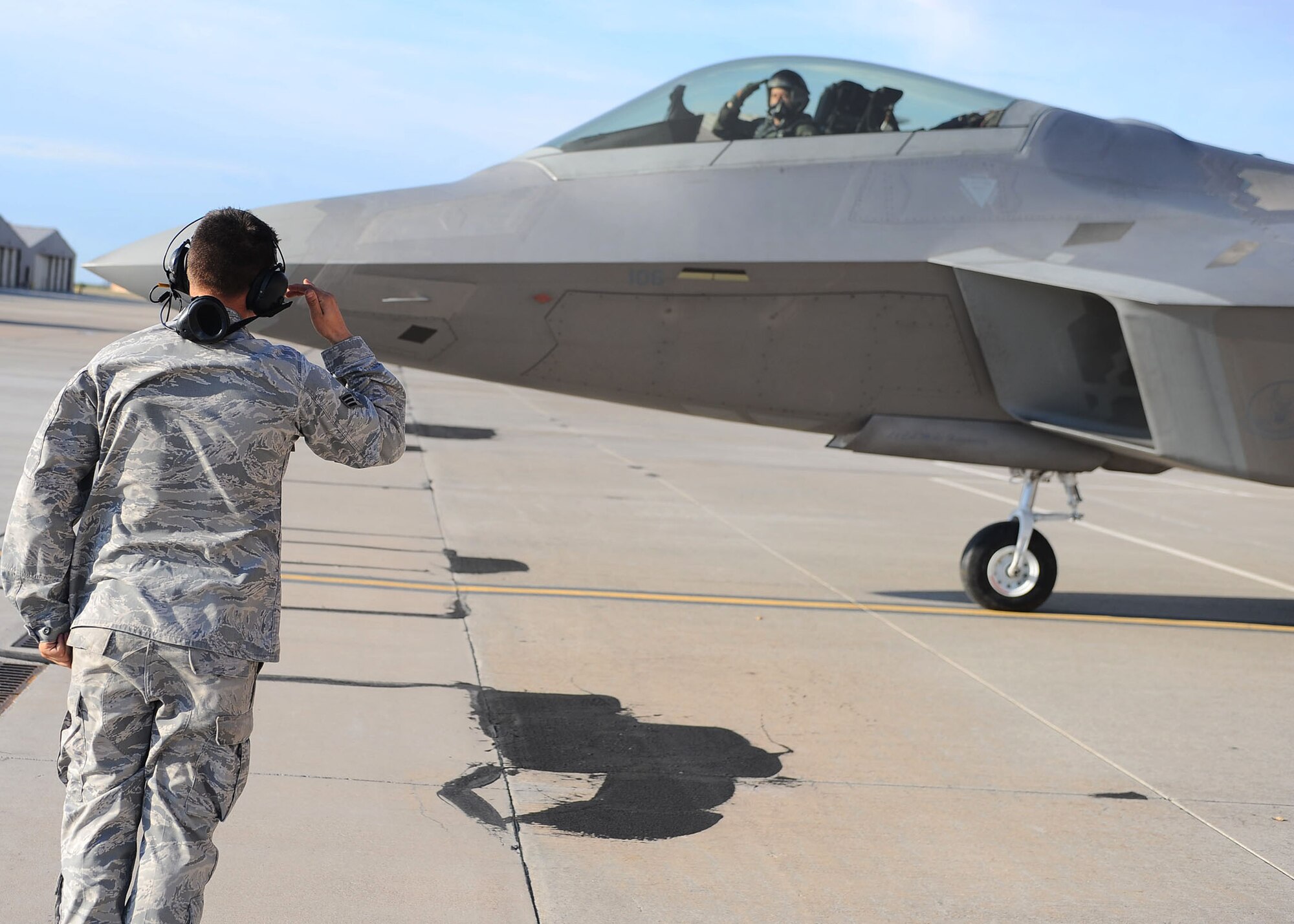Senior Airman Bryan McMahon, 49th Aircraft Maintenance Unit, renders a salute to Lt. Col. Mike Hernandez, 7th Fighter Squadron commander, as he departs in an F-22A Raptor for a Red Flag exercise, at Holloman Air Force Base, N.M., July 18. Airman McMahon was a part of a two-man team who prepared the F-22 for takeoff. (U.S. Air Force photo/ Airman 1st Class DeAndre Curtiss)