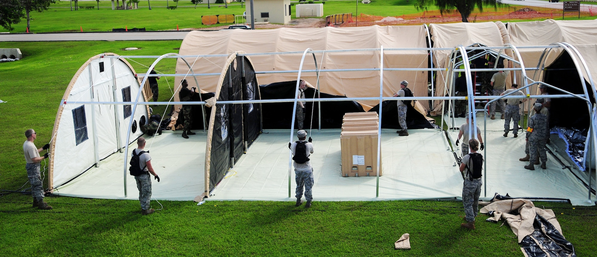 Members of the 36th Medical Group and the 36th Contingency Response Group work together to construct operational tents during a simulated exercise for the Humanitarian Assistance Rapid Response Team July 15 at Andersen Air Force Base, Guam. The HARRT is equipped to operate in an austere permissive environment during Phase III of disaster relief operations, supporting 350 to 500 patients per day and can be fully operational within six hours of arrival at the disaster site. (U.S. Air Force photo/Airman 1st Class Courtney Witt) 
