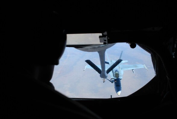 Beyond the silhouette of Staff Sgt. Kenneth Harwood, a Royal Australian Air Force F/A-18 Hornet receives fuel July 19 over Australia. The aircraft were participating in a mock air war over Australia as part of Exercise Talisman Saber 2009. Sergeant Harwood is a 909th Air Refueling Squadron instructor boom operator from Kadena Air Base, Japan. (U.S. Air Force photo/Capt. Bryan Lewis) 