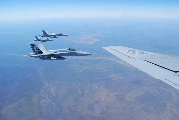 Three Royal Australian Air Force F/A-18 Hornets fly in formation alongside a KC-135 Stratotanker during Exercise Talisman Saber 2009 July 19 over Australia. The RAAF fighters received fuel from the KC-135 in order to continue a mock air war designed to improve combat readiness and interoperability between Australian and U.S. forces. The KC-135 is from the 909th Air Refueling Squadron from Kadena Air Base, Japan. (U.S. Air Force photo/Capt. Bryan Lewis) 