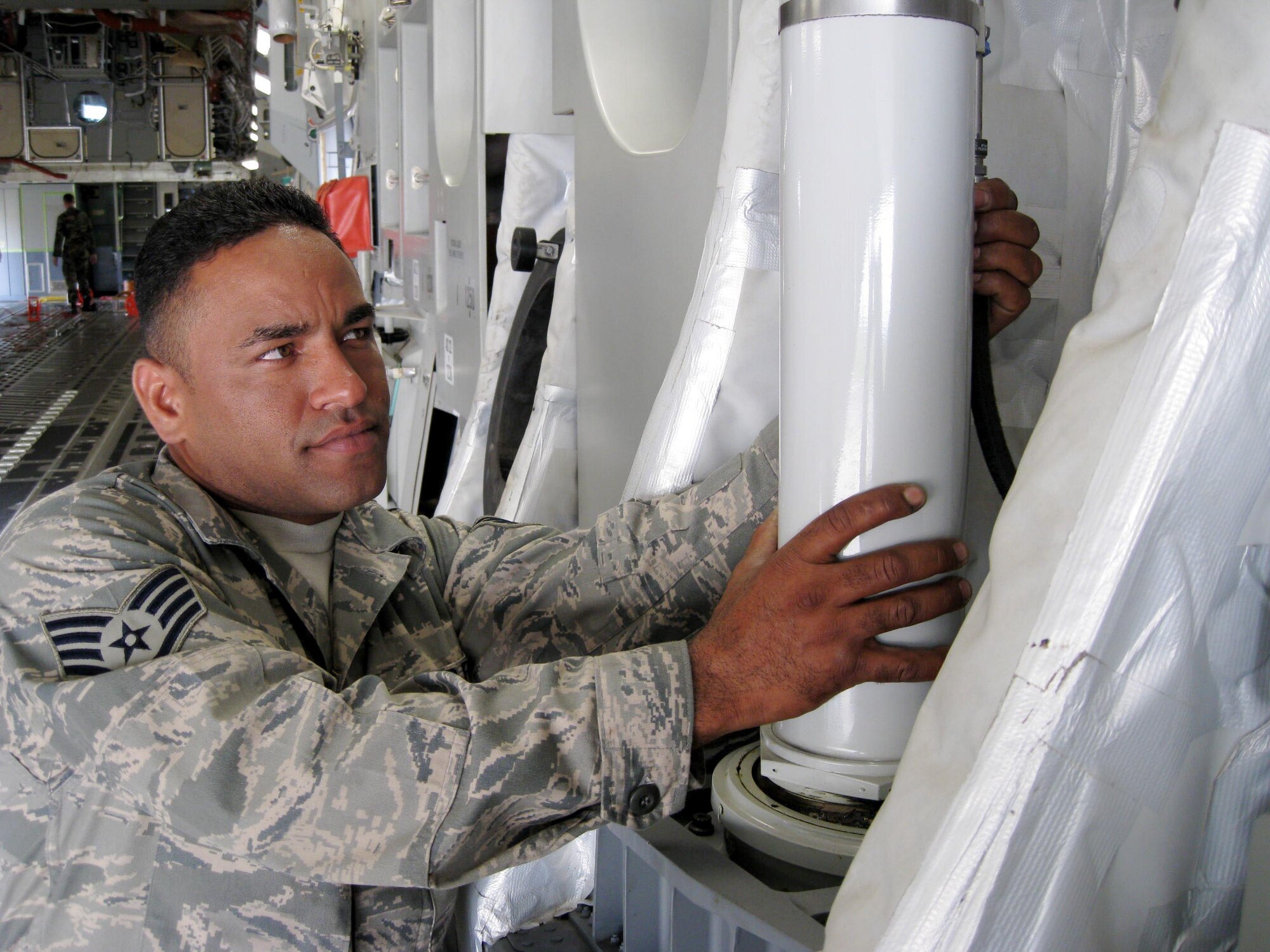 MCGUIRE AIR FORCE BASE,  N.J. - Staff Sgt. Roberto Santisteban checks a ramp actuator or leaks aboard a C-17 Globemaster III here. Sergeant  Santisteban is part of Team McGuire for the Air Mobility Command Rodeo 2009, AMC's premier mobility competition held at McChord Air Force Base, Wash., July 19-26. (U.S. Ai Force photo/Staff Sgt. Monica L. Dalberg)