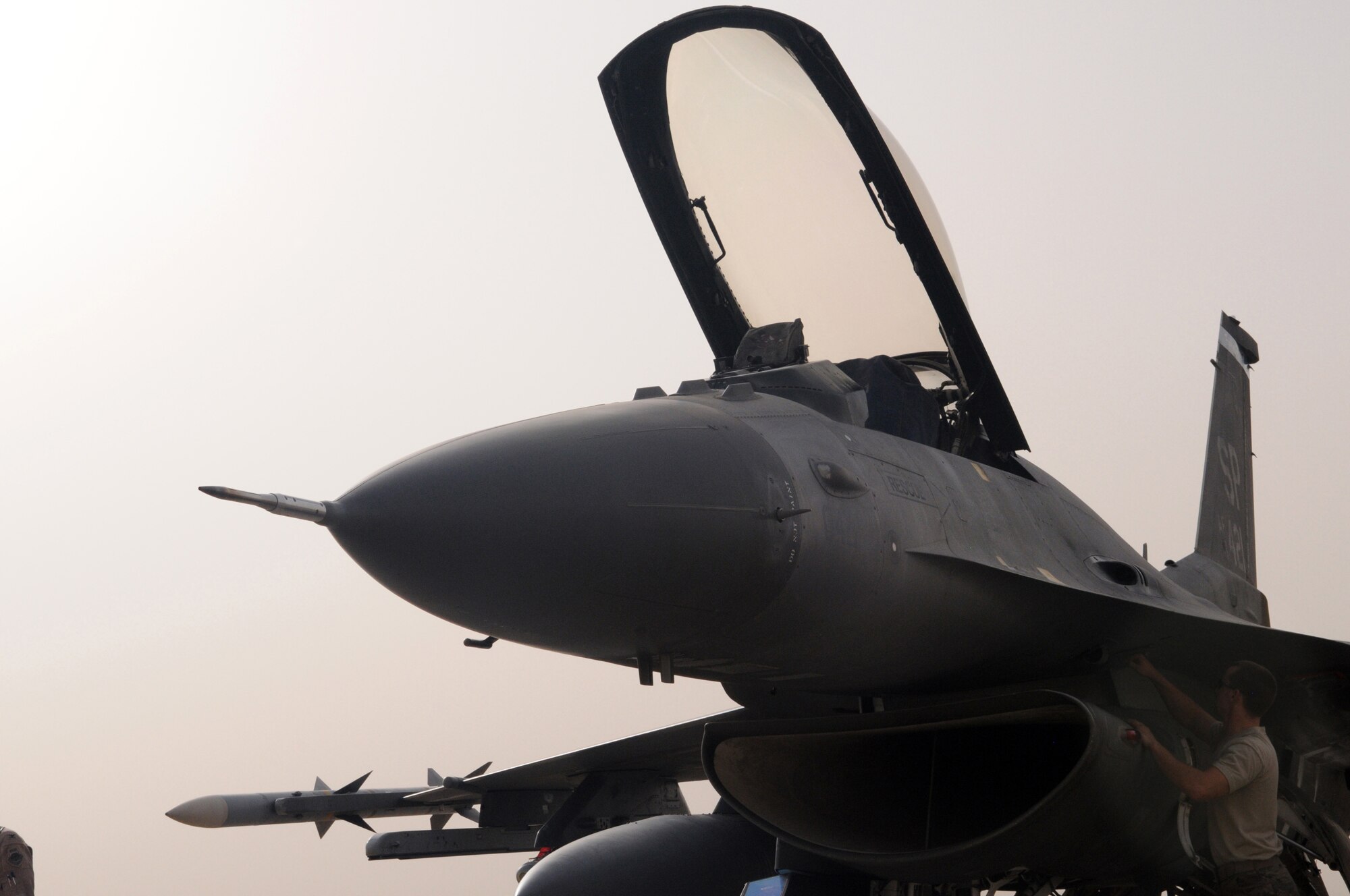 JOINT BASE BALAD, Iraq – An F-16 Fighting Falcon from the 22nd Fighter Squadron at Spangdahlem Air Base, Germany, receives service from Airman 1st Class Matthey Myers, 332nd Expeditionary Aircraft Maintenance Squadron, after returning from a combat sortie flown July 17.  The jets are assigned to Joint Base Balad in support of Operation Iraqi Freedom. (U.S. Air Force photo by Staff Sgt. Heather Norris)