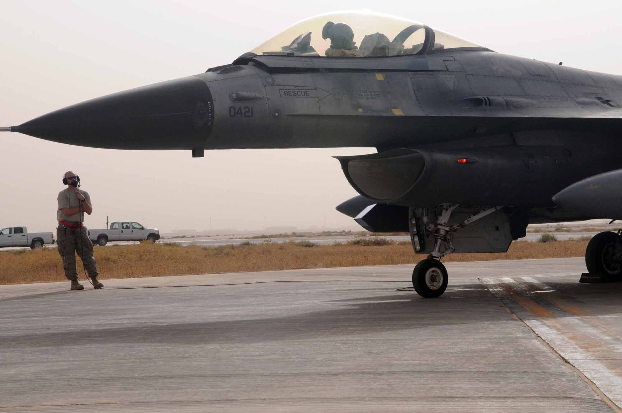 JOINT BASE BALAD, Iraq -- A crew member provides instructions to Col. John Dolan, outgoing 332nd Air Expeditionary Wing vice commander, after returning from a combat sortie flown July 17.  F-16 Fighting Falcons from the 22nd Fighter Squadron at Spangdahlem Air Base, Germany, are assigned to Joint Base Balad in support of Operation Iraqi Freedom. (U.S. Air Force photo by Staff Sgt. Heather Norris)