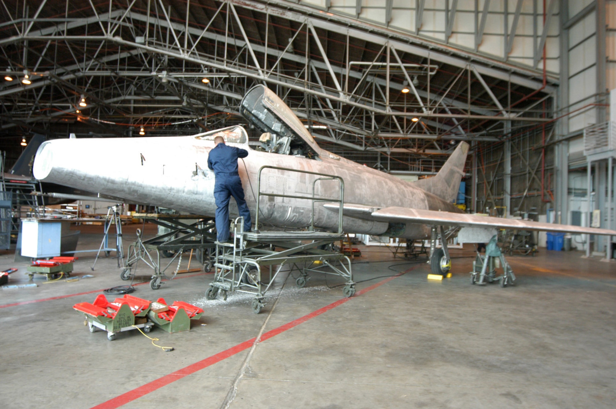Airmen of the 653rd Combat Logistics Support Squadron provide corrosion control for the Robins’ Museum of Aviation's F-100. (Air Force photo by Sue Sapp)  
