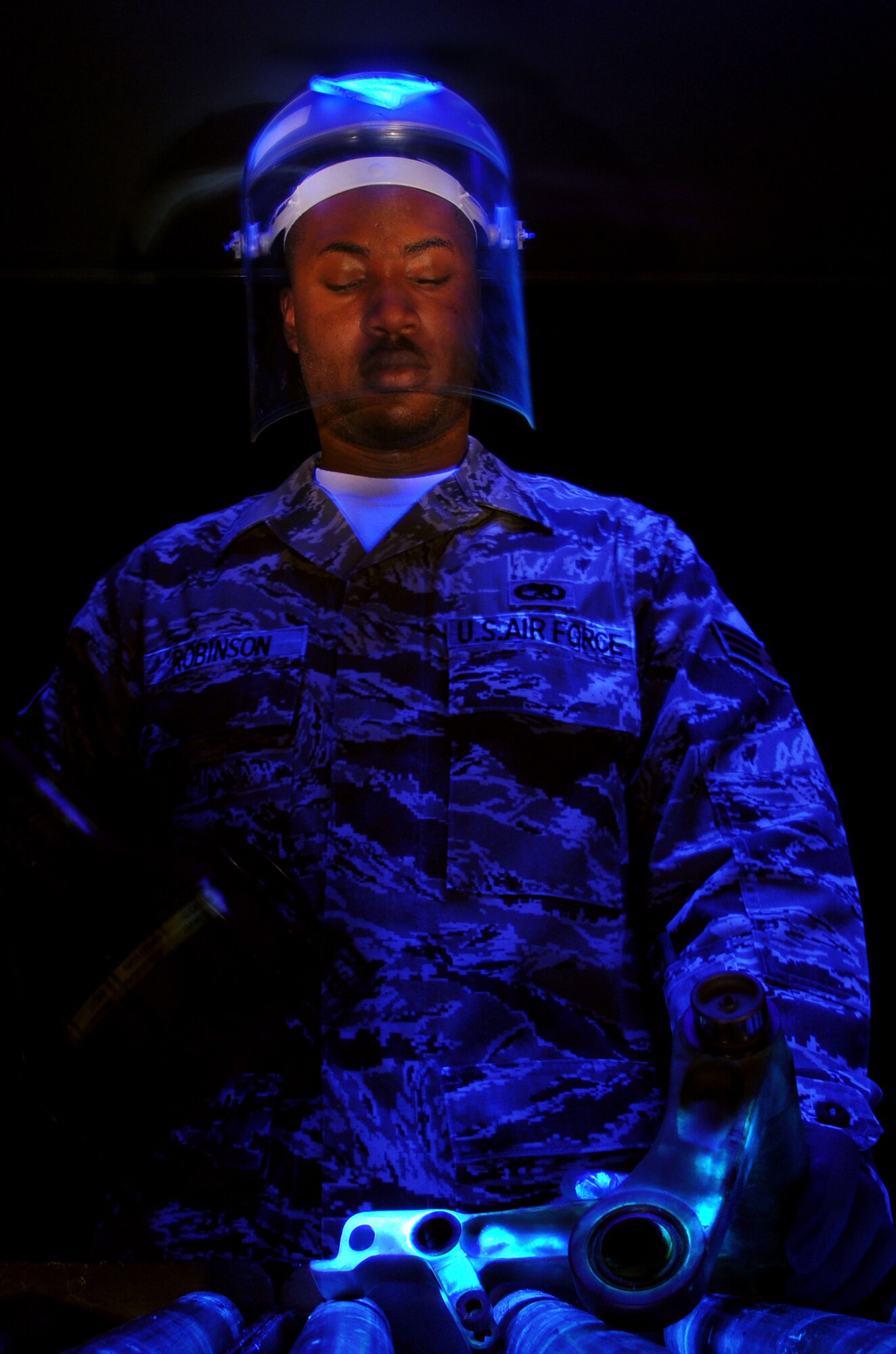 Senior Airman Joshua Robinson, 48th Equipment Maintenance Squadron Non-Destruction Inspection journeyman, inspects a component for cracks after it?s been dipped in fluorescent chemicals, which light up under black light. The process has been designed to allow Airman Robinson to find cracks and other defects in the various components he inspects, without damaging them. (U.S. Air Force photo by Staff Sgt. Nathan Gallahan)