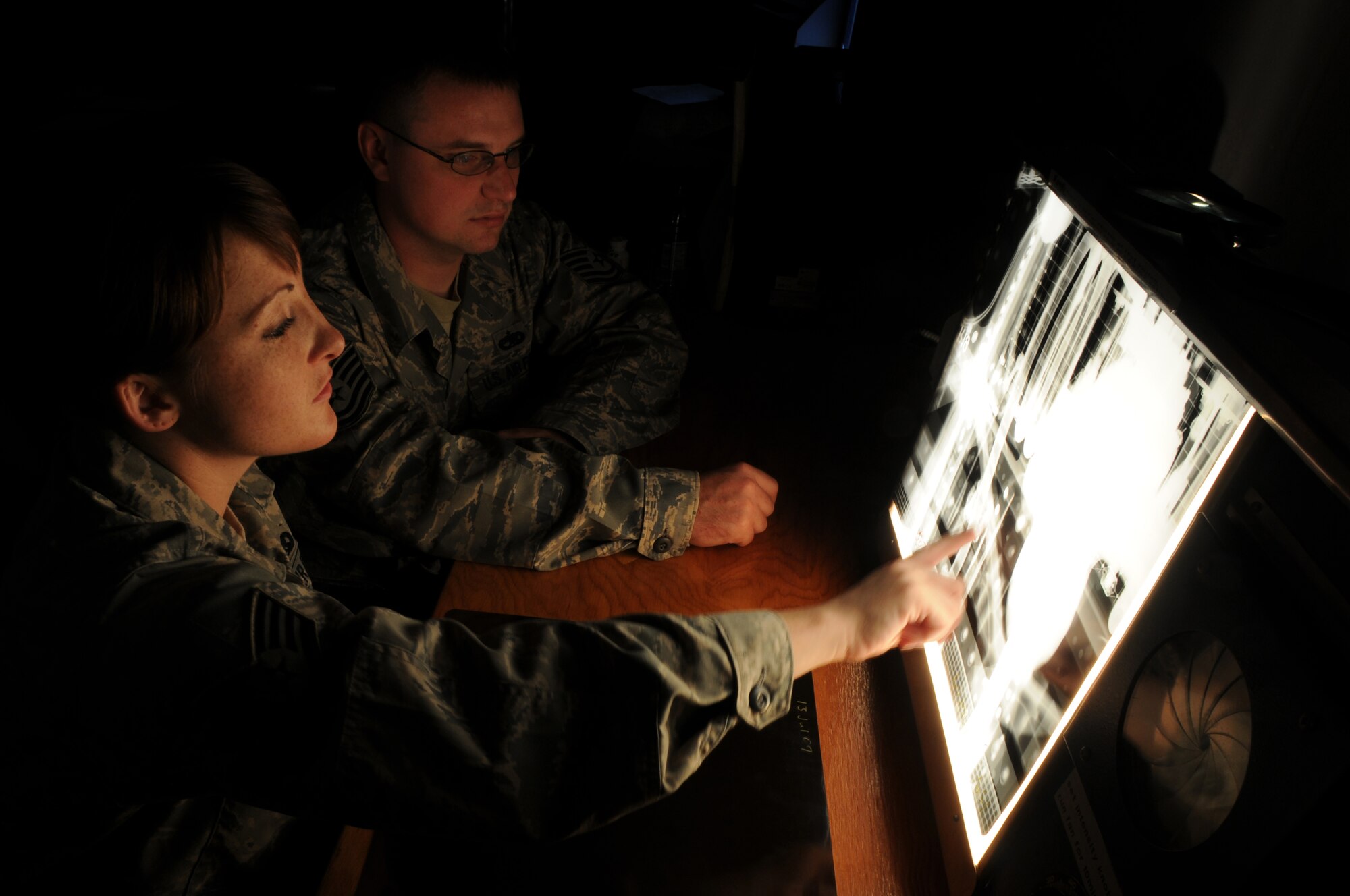 Staff Sgt. Cortney Coker, 48th Equipment Maintenance Squadron Non-Destruction Inspection journeyman, looks over an x-ray image of a section of F-15E Strike Eagle with Tech. Sgt. Sterling Rosenau, an F-15 phase crew chief with the same squadron. X-rays of the aircraft are taken pre and post inspection and then compared for variations or defects. (U.S. Air Force photo by Staff Sgt. Nathan Gallahan)
