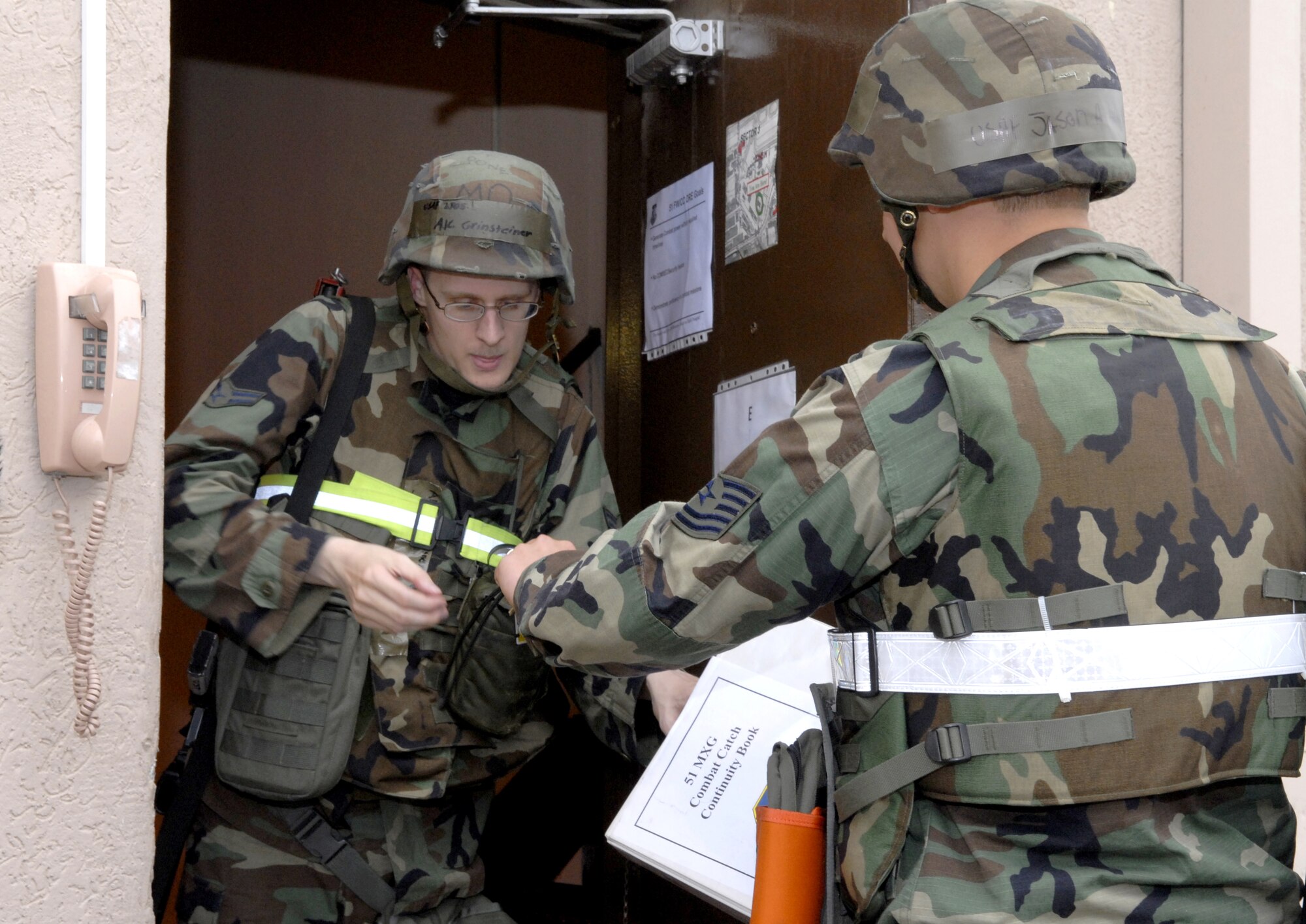 Airman 1st Class Derek Grinsteiner inspects an ID card while on door guard during Operational Readiness Exercise Beverly Bulldog 09-03 here July 20. Beverly Bulldog 09-03 is scheduled for July 20-24.  (U.S. Air Force photo/Senior Airman Stephenie Wade)