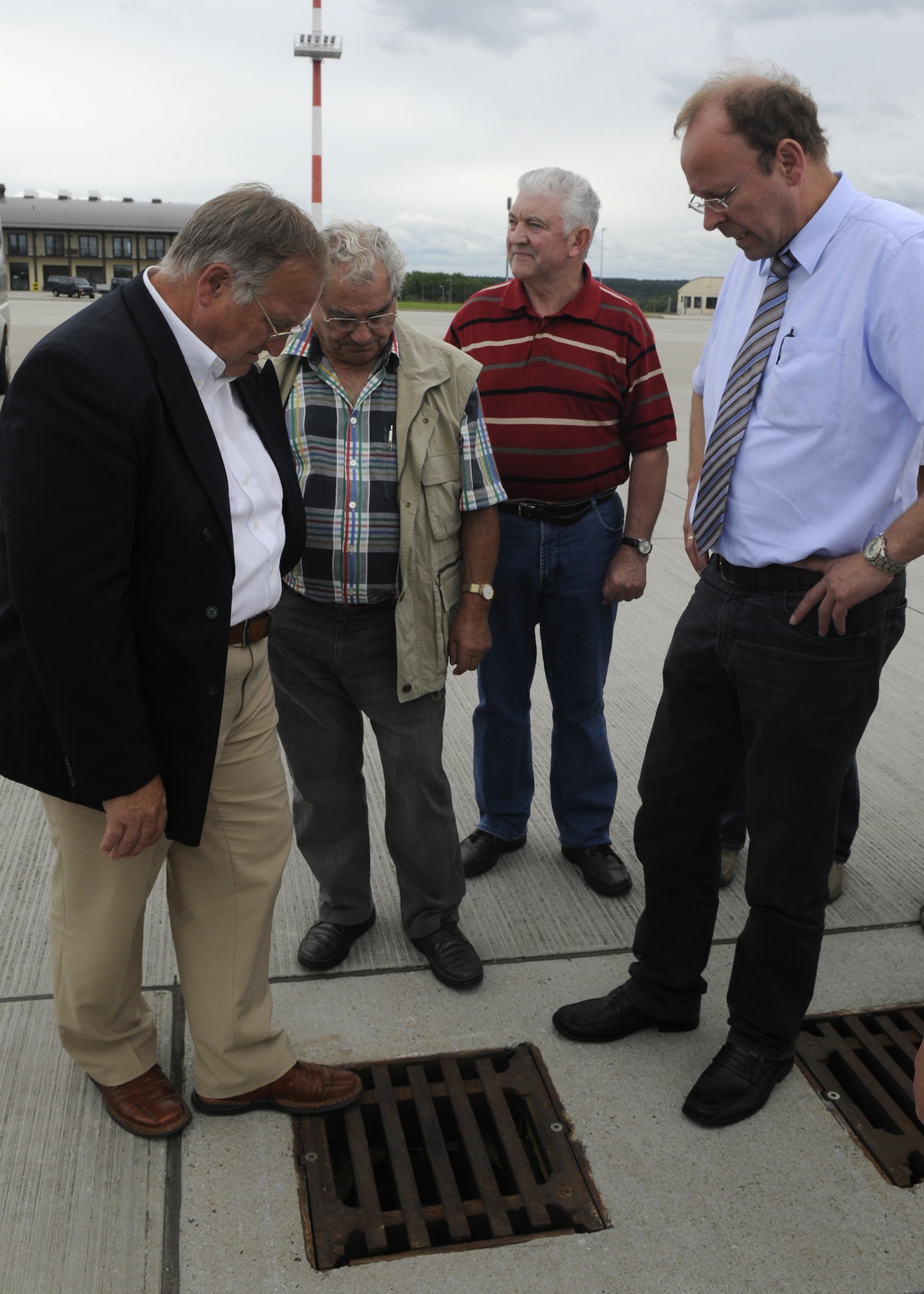 SPANGDAHLEM AIR BASE, Germany – (left to right) Lothar Herres, outgoing Binsfeld mayor; Werner Pitsch and Ernest Kroeschel, Binsfeld council members; and Udo Stuermer, 52nd Civil Engineer Squadron Programs Flight chief, look at the new Safe Drain System at the 726th Air Mobility Squadron July 17. The Safe Drain inlet closes completely in seconds allowing rapid response to spills  The mayors and council members toured different areas around base to see recent improvements, to include better drains and a noise reducing blast fence installed to provide better community relations between Binsfeld and the 52nd Fighter Wing. (U.S. Air Force photo by Airman 1st Class Staci Miller)