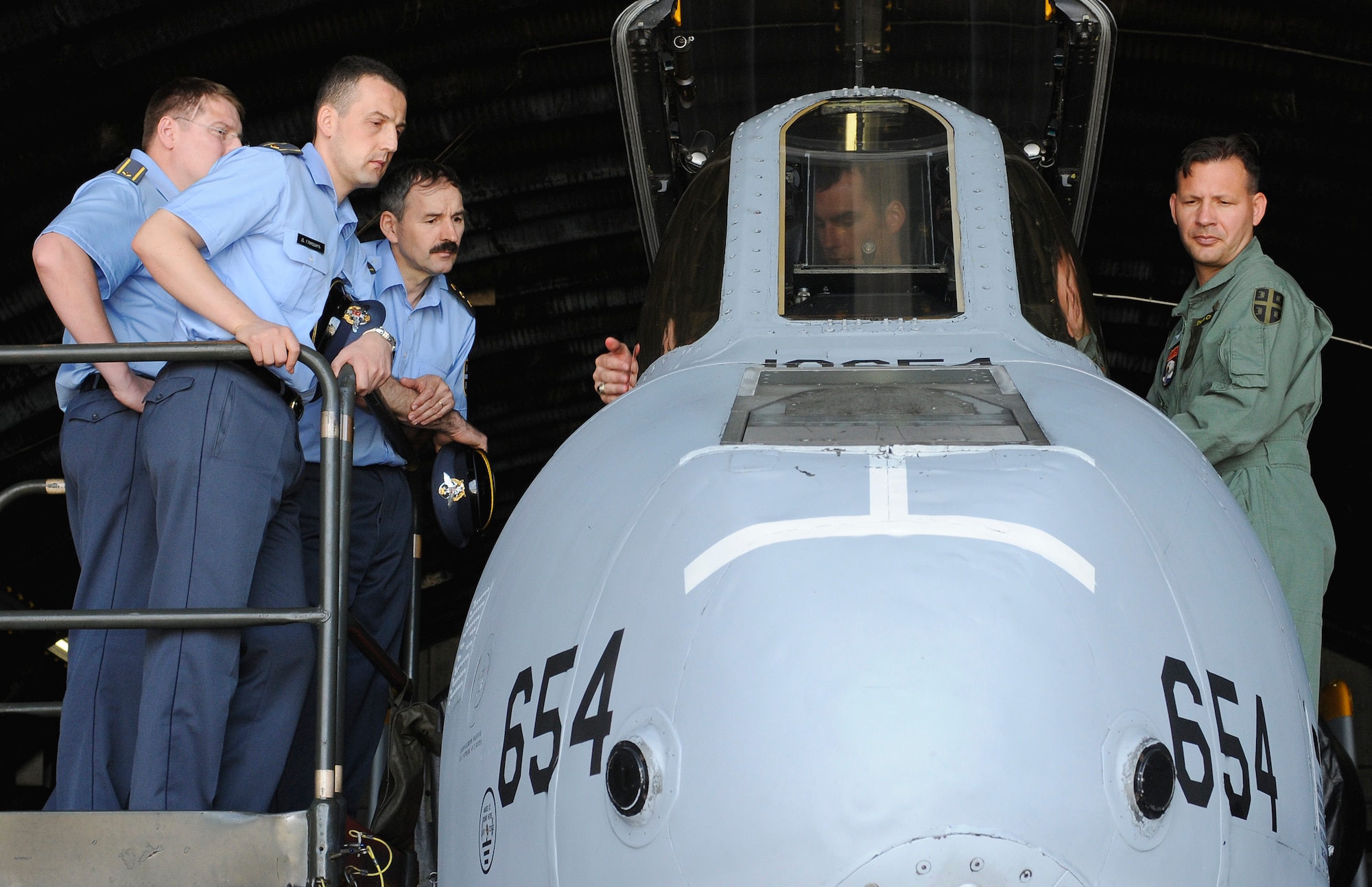 SPANGDAHLEM AIR BASE, Germany – Capt. Jeffery Dennis, 81st Fighter Squadron, sits in the pilot’s seat of an A-10 Warthog and explains its features to distinguished visitors from the Serbian air force July 16. Four members of the Serbian air force came to Spangdahlem to learn how a fighter squadron runs as part of their visit to the 603rd Air and Space Operations Center located at Ramstein Air Base, Germany.. (U.S. Air Force photo/Senior Airman Benjamin Wilson)