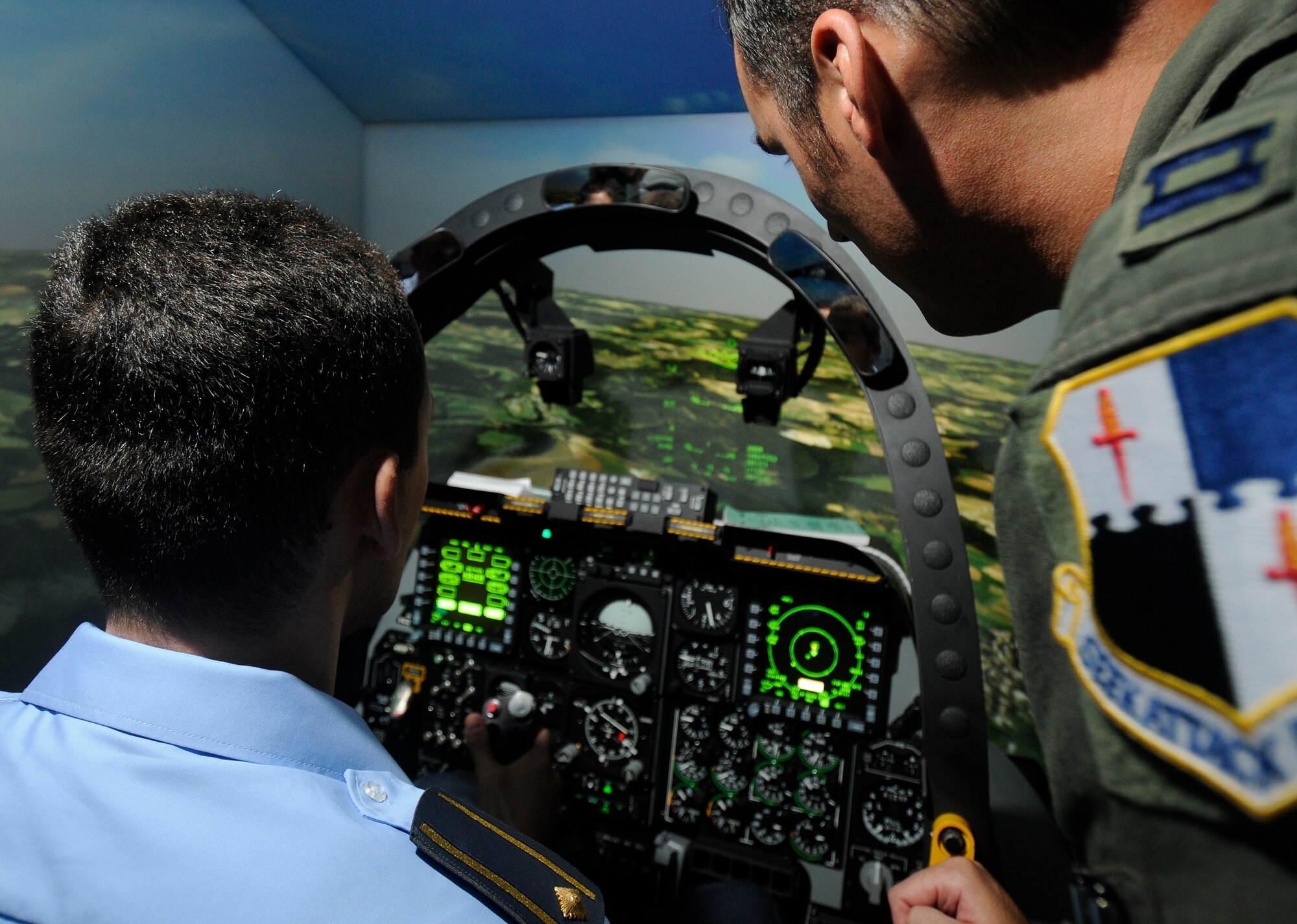 SPANGDAHLEM AIR BASE, Germany – Capt. Jeffery Dennis, 81st Fighter Squadron, instructs Maj. Darko Glisic, A-2 desk officer for the Serbian Air Force and Air Defense Command, as he flies in a simulated “dog fight” during his visit to Spangdahlem Air Base July 16. Four members of the Serbian air force came to Spangdahlem to learn how a fighter squadron runs as part of their visit to the 603rd Air and Space Operations Center located at Ramstein Air Base, Germany.. (U.S. Air Force photo/Senior Airman Benjamin Wilson)