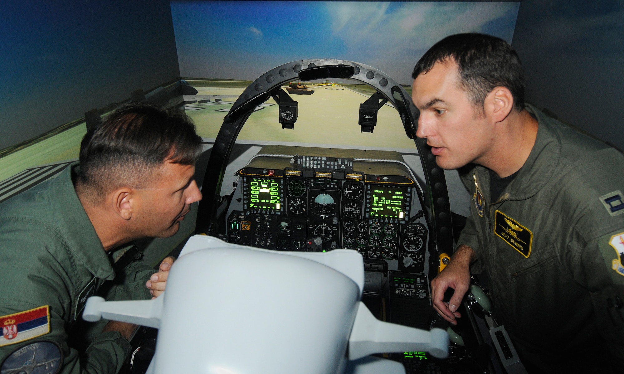 SPANGDAHLEM AIR BASE, Germany – Capt. Jeffery Dennis, 81st Fighter Squadron, explains the components of an A-10 Thunderbolt II simulator to Lt. Col. Roberto Delakroce, B-2 Spirit chief for the 204th Air Base of the Serbian air force, during his visit to Spangdahlem Air Base July 16. Four members of the Serbian air force came to Spangdahlem to learn how a fighter squadron runs as part of their visit to the 603rd Air and Space Operations Center located at Ramstein Air Base, Germany. (U.S. Air Force photo/Senior Airman Benjamin Wilson)