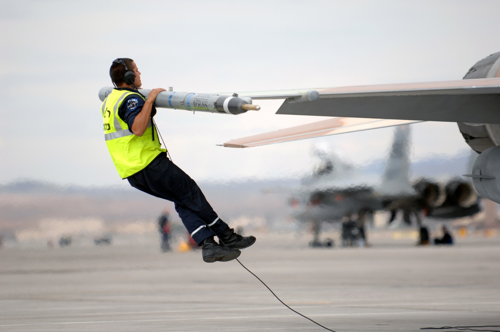Nir, A crew chief from Ramon Air Base, Israel jumps up to check the top of a F-16C Falcon July 20, 2009 during Red Flag 09-4. Red Flag is a realistic combat training exercise involving the air forces of the United States and its allies. The exercise is conducted on the 15,000-square-mile Nevada Test and Training Range, north of Las Vegas. Flying for Red Flag 09-4 begins July 13 and ends July 24. U.S. aircraft will come from Nellis and Creech in Nevada, South Carolina, Idaho, the United Kingdom, Washington, Oklahoma and Ohio. Aircraft types will include F-15s, F-16s, E-3s and KC-135s. In addition to U.S. aircraft, the Israeli Air Force will be flying F-16C  Falcons. (U.S. Air Force photo by Airman 1st Class Brett Clashman)
