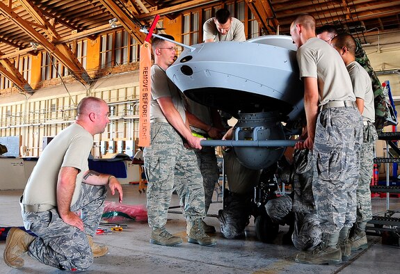 HOLLOMAN AIR FORCE BASE, N.M. -- Members of 432nd Wing place a sensor pod in an MQ-1B Predator July 8 here. (U.S. Air Force photo by Tech. Sgt. Chris Flahive)(Released)