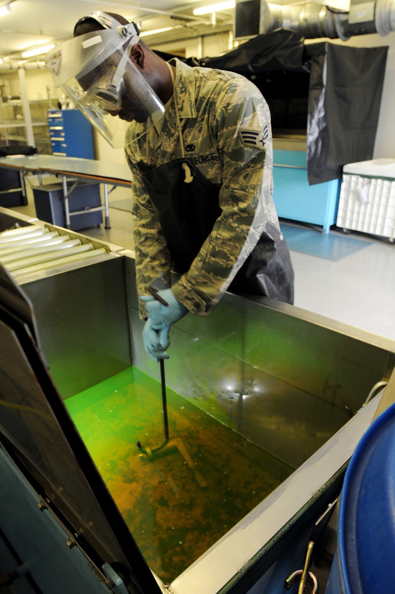 Senior Airman Joshua Robinson dips a component into a chemical penetrent, which lights up under black light July 17 at Royal Air Force Lakenheath, England. After the component is dipped into the chemical, the surface is then cleaned, leaving only the fluorescence in the cracks of the component. This allows the cracks to be easily found when the fluorescence lights up under black light. Airman Robinson is a 48th Equipment Maintenance Squadron nondestruction inspection journeyman. (U.S. Air Force photo/Staff Sgt. Nathan Gallahan) 