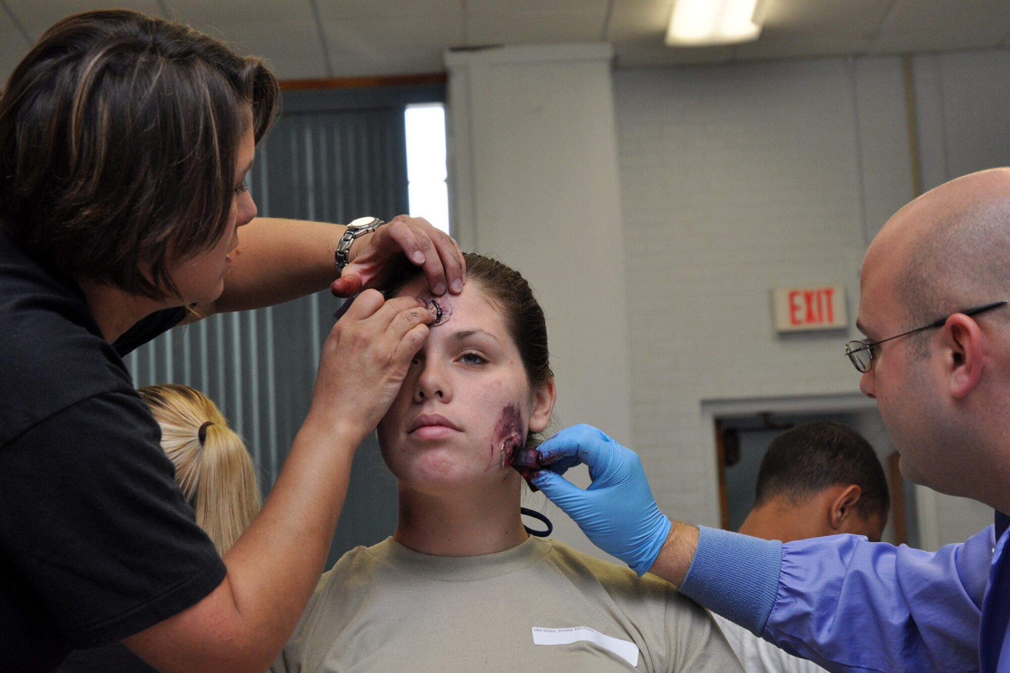 EGLIN AIR FORCE BASE, Fla. – Tech. Sgt. Michele Edmond and Senior Airman Aaron Gerasch, 96th Medical Support Squadron moulage team, apply moulage to Airman Emily Dow, medical student, at the West Gate Chapel for an exercise July 22. Moulaging victims for exercise scenarios enable medical personnel to better train for real-world possible situations when they deploy. (U.S. Air Force photo/ Airman Anthony Jennings)