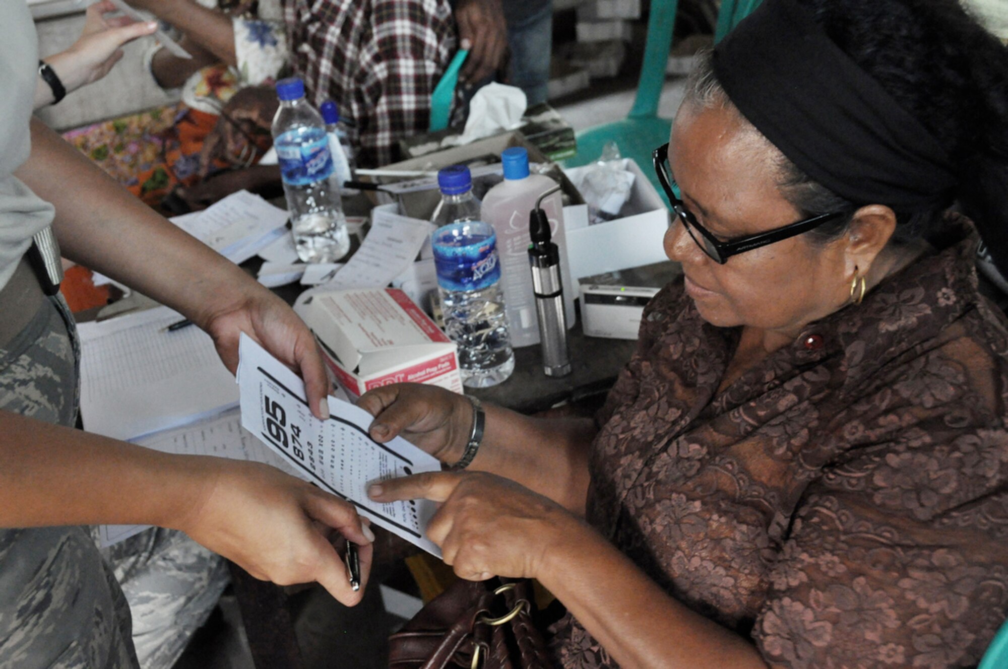 An East Timorese woman verifies her vision has improved with a new pair of glasses after being seen by Air Force eye specialists July 20 at a clinic in Dili, Timor Leste. The clinic was set up as part of Operation Pacific Angel 2009, a Pacific Air Forces humanitarian assistance operation in the Asia-Pacific region led by 13th Air Force at Hickam Air Force Base, Hawaii. (U.S. Air Force photo/Tech. Sgt. Cohen A. Young)