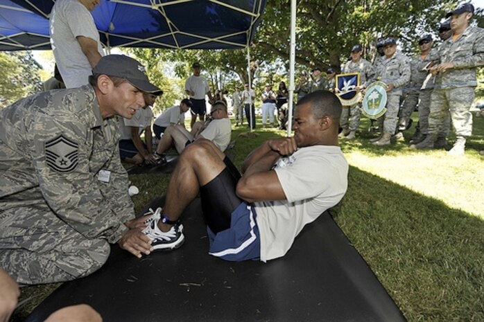 Senior Master Sgt. Damian Fox braces Airman 1st Class James Lipscomb during the situps portion of the "Fit-to-Fight" competition at Air Mobility Rodeo 2009 at McChord AFB, Wash., July 19. Rodeo is an international combat skills and flying operations competition designed to develop and improve techniques and procedures with international partners to enhance mobility operations. Sergeant Fox is a member of the 437th Operations Group and Airman Lipscomb is a member of the 437th Security Forces Squadron. (U.S. Air Force photo/James M. Bowman)