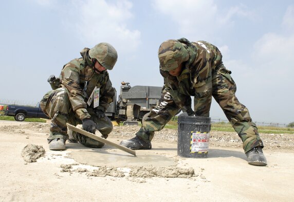 Senior Airmen Jason Vick and Taurean Garret fill a small crater with cement on the simulated flightline during exercise Beverly Bulldog 09-03 at Osan Air Base, Republic of Korea, July 22. Both Airmen are Structural Journeyman assigned to the 51 Civil Engineer Squadron. (U.S. Air Force photo/Senior Airman Stephenie Wade)