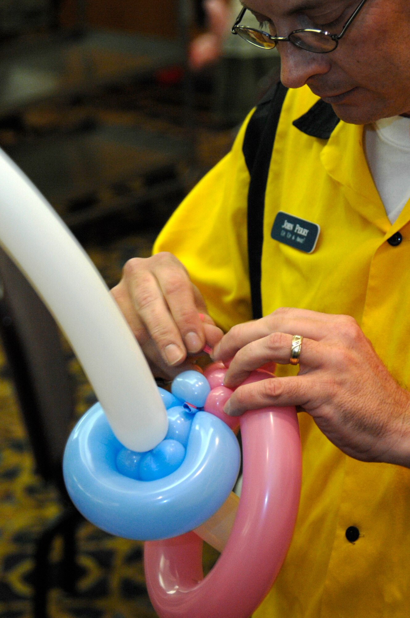 WHITEMAN AIR FORCE BASE, Mo. – John Perry from Up, Up and Away Balloon Artistry bends balloons into the shape of a lollipop July 17 at the Mission’s End for Family Fun Night sponsored by the 509th Force Support Squadron. During Family Fun Night, parents, children and friends can come together to talk play games and meet new friends. (U.S. Air force photo/Staff Sgt. Jason Barebo)