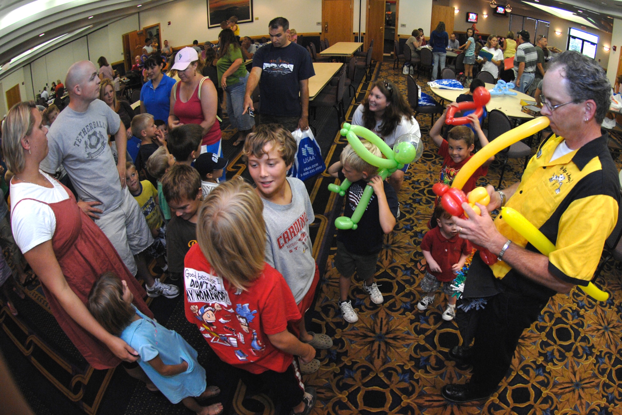 WHITEMAN AIR FORCE BASE, Mo. – John Perry from Up, Up and Away Balloon Artistry bends balloons into the shape of a parrot on a branch for a child July 17 at the Mission’s End for Family Fun Night sponsored by the 509th Force Support Squadron. During Family Fun Night, parents, children and friends can come together to talk play games and meet new friends. During the July 17 Family Fun Night, the first 100 school-aged children received school supplies. (U.S. Air Force photo/Staff Sgt. Jason Barebo)