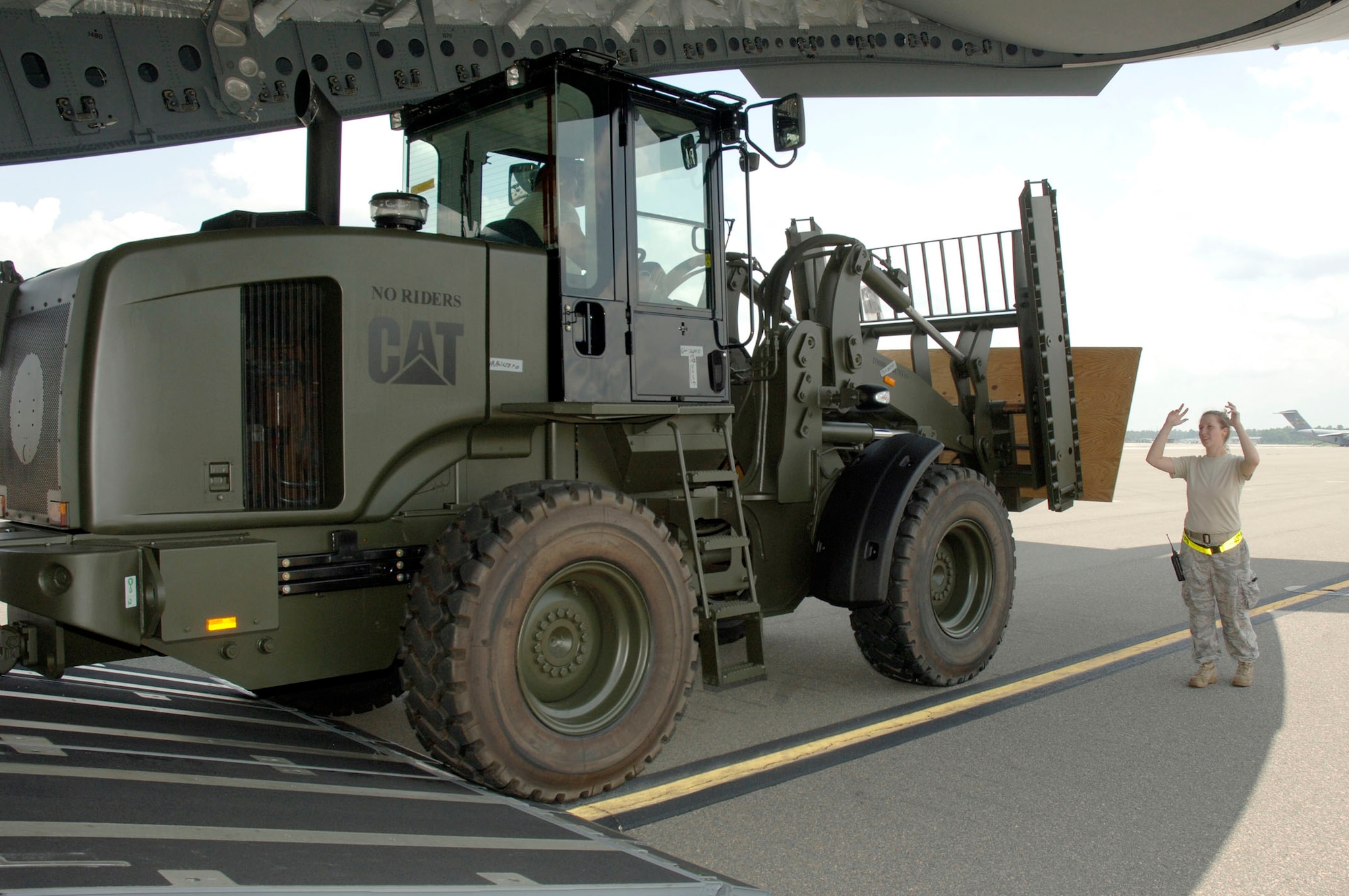 Senior Airman Ashley Kelly marshals a 10K all-terrain forklift onto the back of a C-17 bound for Papa AB, Hungary July 17. The Heavy Airlift Wing at Papa AB is a multi-national wing with all 12 nations of NATO having at least one person participating. Airman Kelly is a load team chief assigned to the 437th Aerial Port Squadron. (U.S. Air Force photo/Staff Sgt. Marie Cassetty)(RELEASED)
