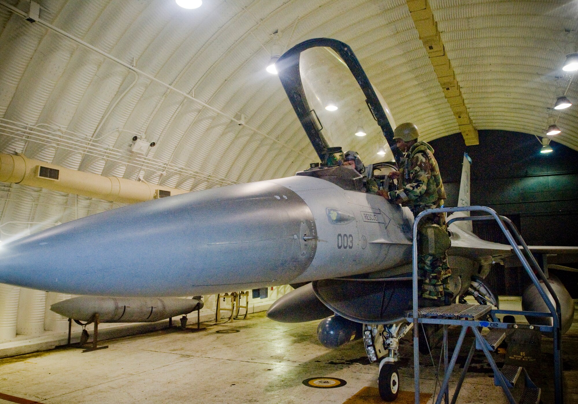 KUNSAN AIR BASE, Republic of Korea -- Airman 1st Class David Hicks, 8th Aircraft Maintenance Squadron, 35th Aircraft Maintenance Unit, helps Lt. Col. Mark Welhaf, 8th Fighter Wing, into an F-16 during an operational readiness exercise here July 22. Airman Hicks and the rest of 8th FW continue the mission, even after switching between mission-oriented protective postures during the exercise. (U.S. Air Force photo/Senior Airman Jonathan Steffen) 