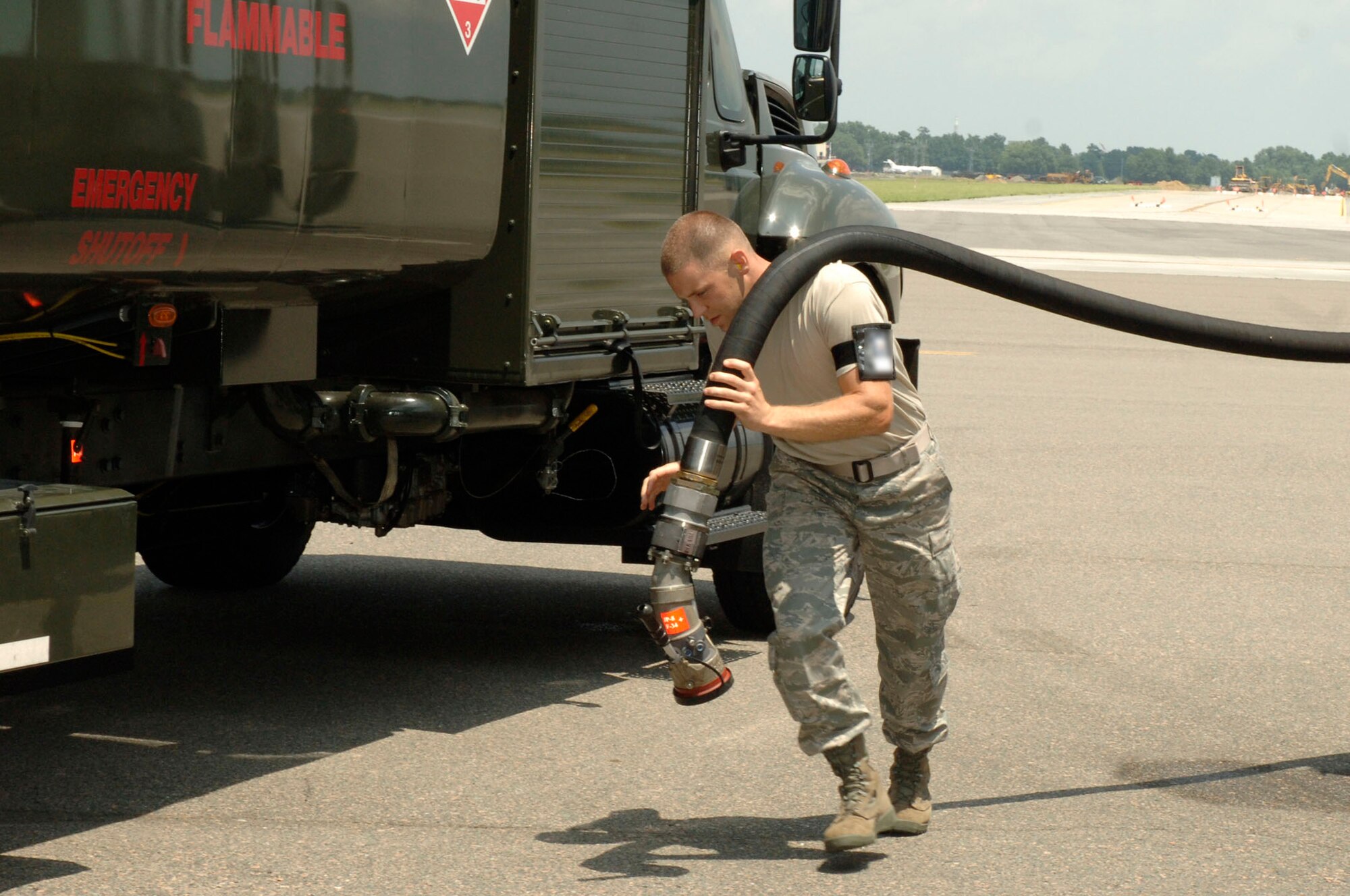 Airman 1st Class Dwight Metheny carries a fuel hose from a fuel truck to a C-17 on the flightline here July 17. A C-17 will hold approximately 180,000 to 245,000 pounds of fuel. Airman Metheny is a fuels technician assigned to the 437th Logistics Readiness Squadron. (U.S. Air Force photo/Staff Sgt. Marie Cassetty)