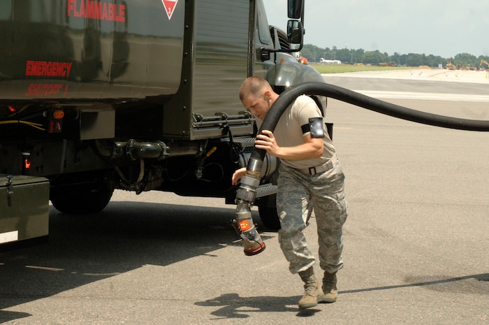 Airman 1st Class Dwight Metheny carries a fuel hose from a fuel truck to a C-17 on the flightline here July 17. A C-17 will hold approximately 180,000 to 245,000 pounds of fuel. Airman Metheny is a fuels technician assigned to the 437th Logistics Readiness Squadron. (U.S. Air Force photo/Staff Sgt. Marie Cassetty)