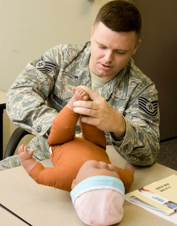 Tech. Sgt. Mark Wood practices changing diapers during a class for new dads hosted by the 437th Medical Group here July 21. The class was led by two instructors who gave four first-time dads hands-on training in childcare. Sergeant Wood is expecting his first child in January and is a vehicle operator with the 437th Logistics Readiness Squadron. (U.S. Air Force photo/Laurie Ladd)