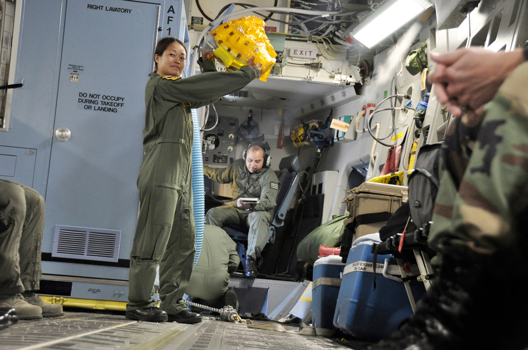 Tech. Sgt. Kimberly Kido demonstrates the proper use of the emergency passenger oxygen system to passengers before departing to support of Operation Pacific Angel 2009 from Hickam Air Force Base, Hawaii July 14 for Kupang, Indonesia. Sergeant Kido is a loadmaster with the Hawaii Air National Guard's 204th Airlift Squadron at Hickam. (U.S. Air Force photo/Tech. Sgt. Cohen A. Young)
