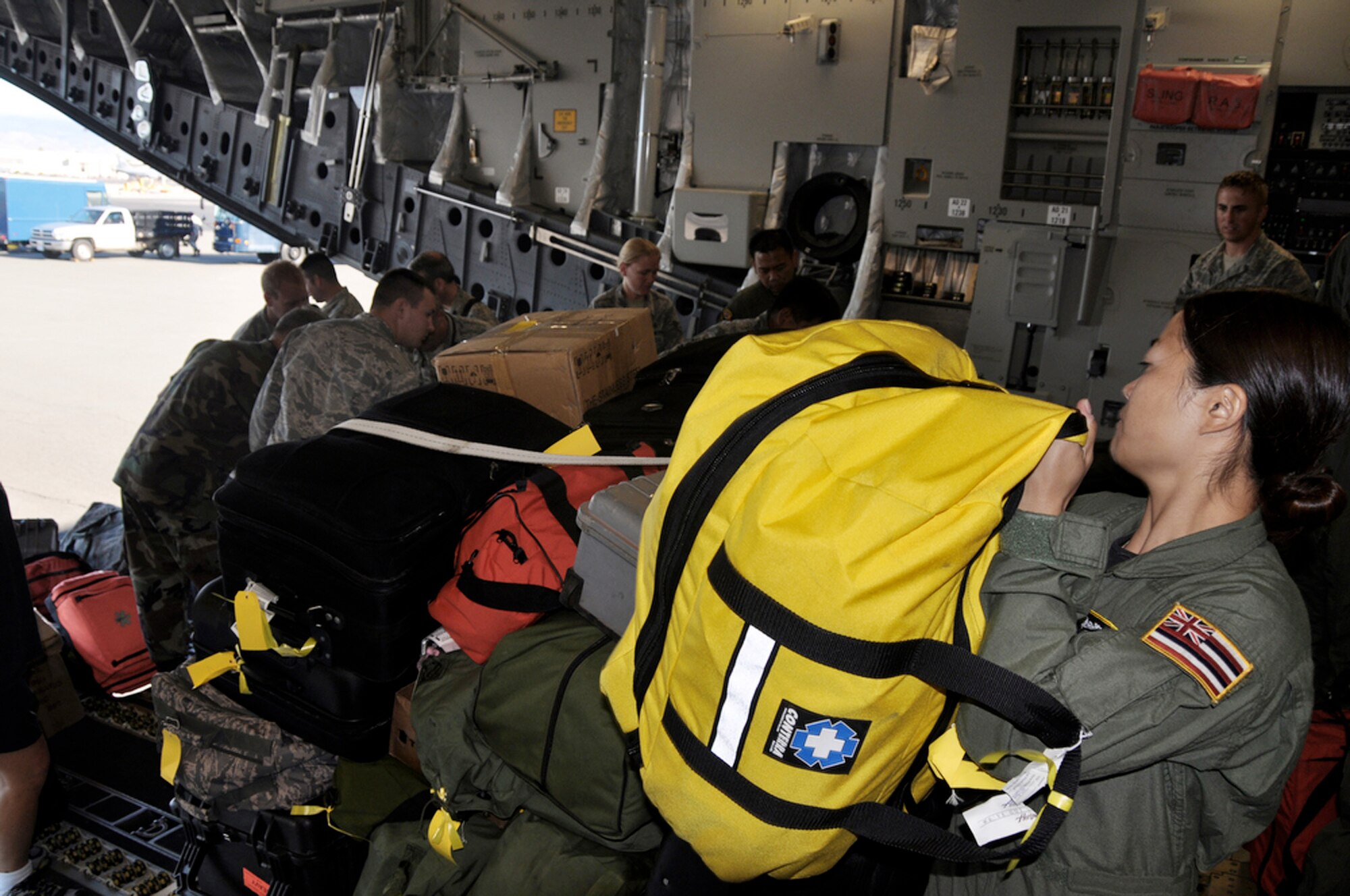 Tech. Sgt. Kimberly Kido prepares to strap down medical bags on a C-17 Globemaster III to support Operation Pacific Angel 2009 July 14 at Hickam Air Force Base, Hawaii, before departing for Kupang, Indonesia. Sergeant Kido is a loadmaster with the Hawaii Air National Guard's 204th Airlift Squadron at Hickam. (U.S. Air Force photo/Tech. Sgt. Cohen A. Young)