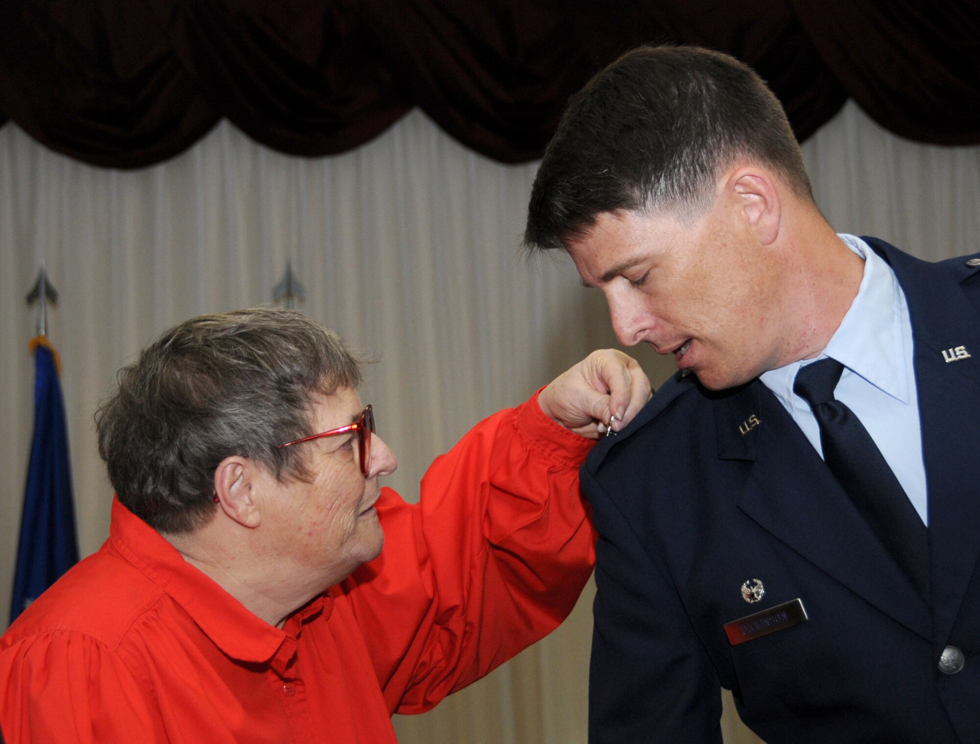 Sheila Dickinson pins a star on her son’s shoulder during Monday’s ceremony.   (U.S. Air Force photo by Kemberly Groue)