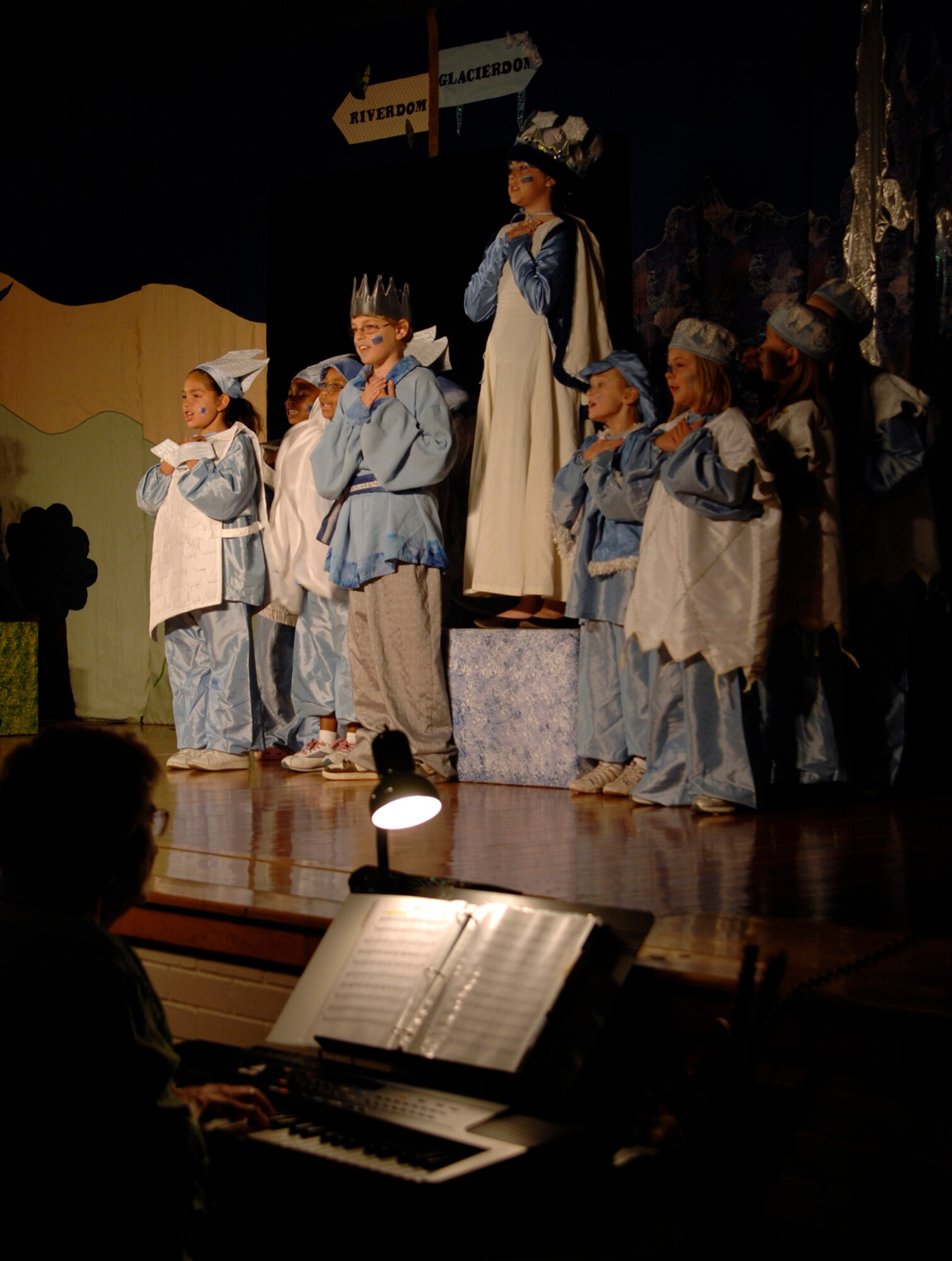 MCCONNELL AIR FORCE BASE, Kan. -- Jill Slaydon, keyboard accompanist, plays selections from the play “The Princess and the Pea,” as cast members known as the kingdom of glacierdom sing along on stage at the base theater, July 18.  Michael McGill wrote the play as well as music and lyrics. (Photo by Senior Airman Laura Suttles)