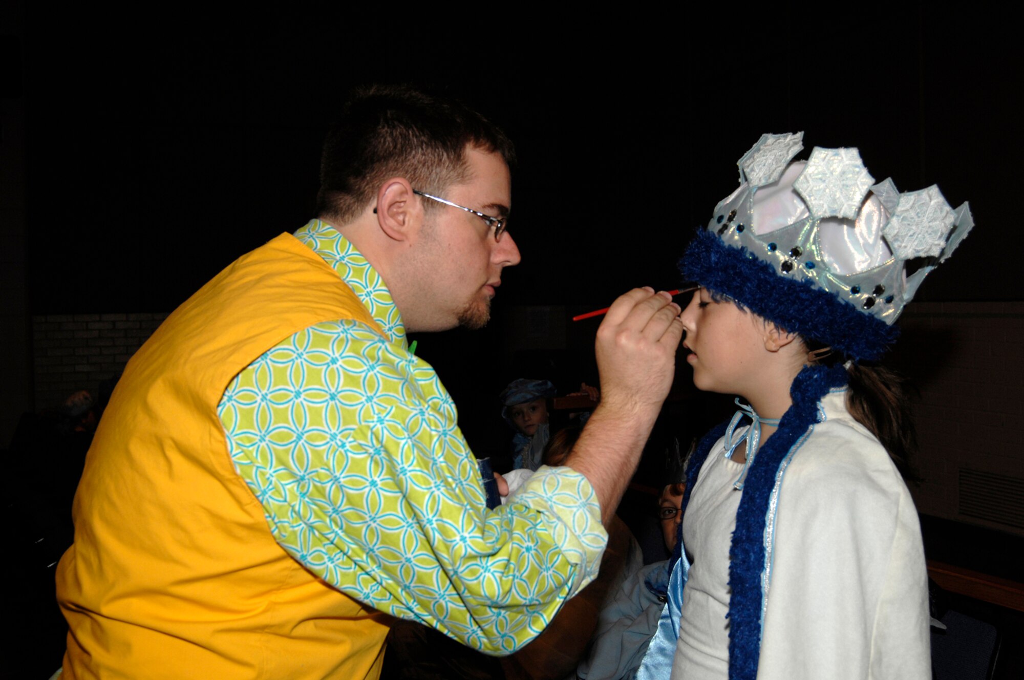 MCCONNELL AIR FORCE BASE, Kan. -- Jeffery Staso, Missoula Children’s Theatre actor and director, applies make-up to Lindsey Burdick, daughter of Airman 1st Class Benjamin Burdick, 22nd Civil Engineer Squadron, before a play at the base theater, July 18. Mr. Staso also plays the part of the chief of leprechauns in the play “The Princess and the Pea.” (Photo by Senior Airman Laura Suttles)