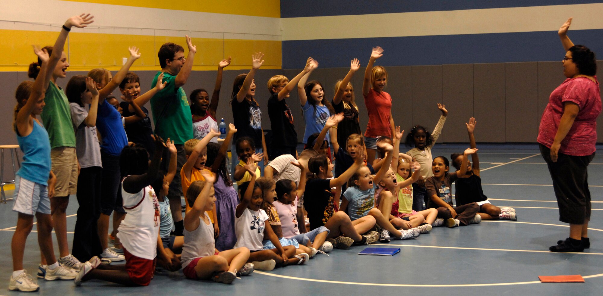 MCCONNELL AIR FORCE BASE, Kan. -- Lynda Mondragon, a tour director for the Missoula Children’s Theatre, leads a group of children in singing at the base Youth Center, July 15. Mrs. Mondragon and Jeffery Staso are one of 47 teams throughout the country promoting the Missoula program and its plays. (Photo by Senior Airman Laura Suttles)