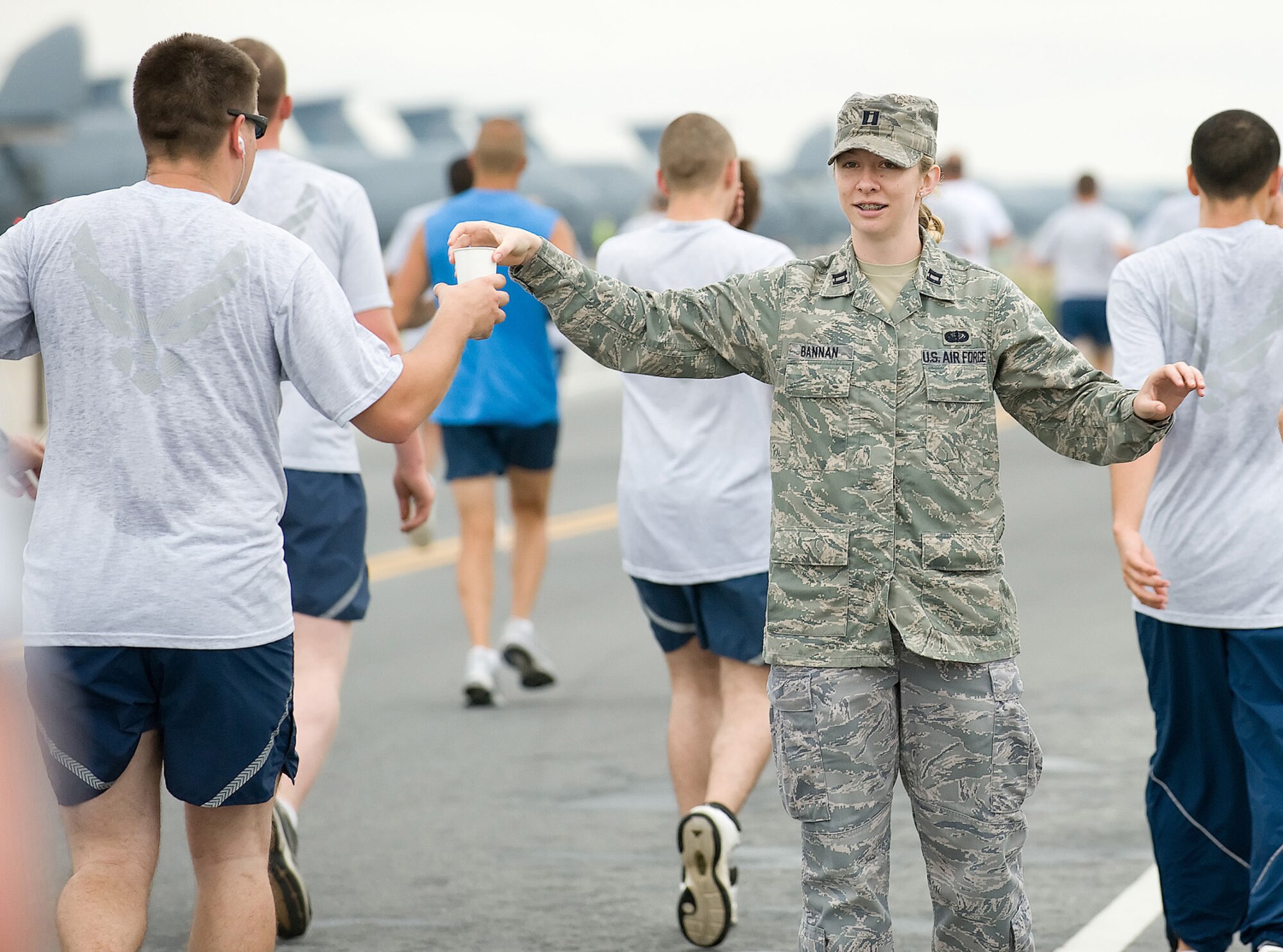 Capt. Sandra Bannan, deployed to the Air Force Mortuary Affairs Operations Center, hands water to Staff Sgt. Brandon Nicely, 436th Force Support Squadron, during the warrior run July 21. (U.S. Air Force photo/Jason Minto)