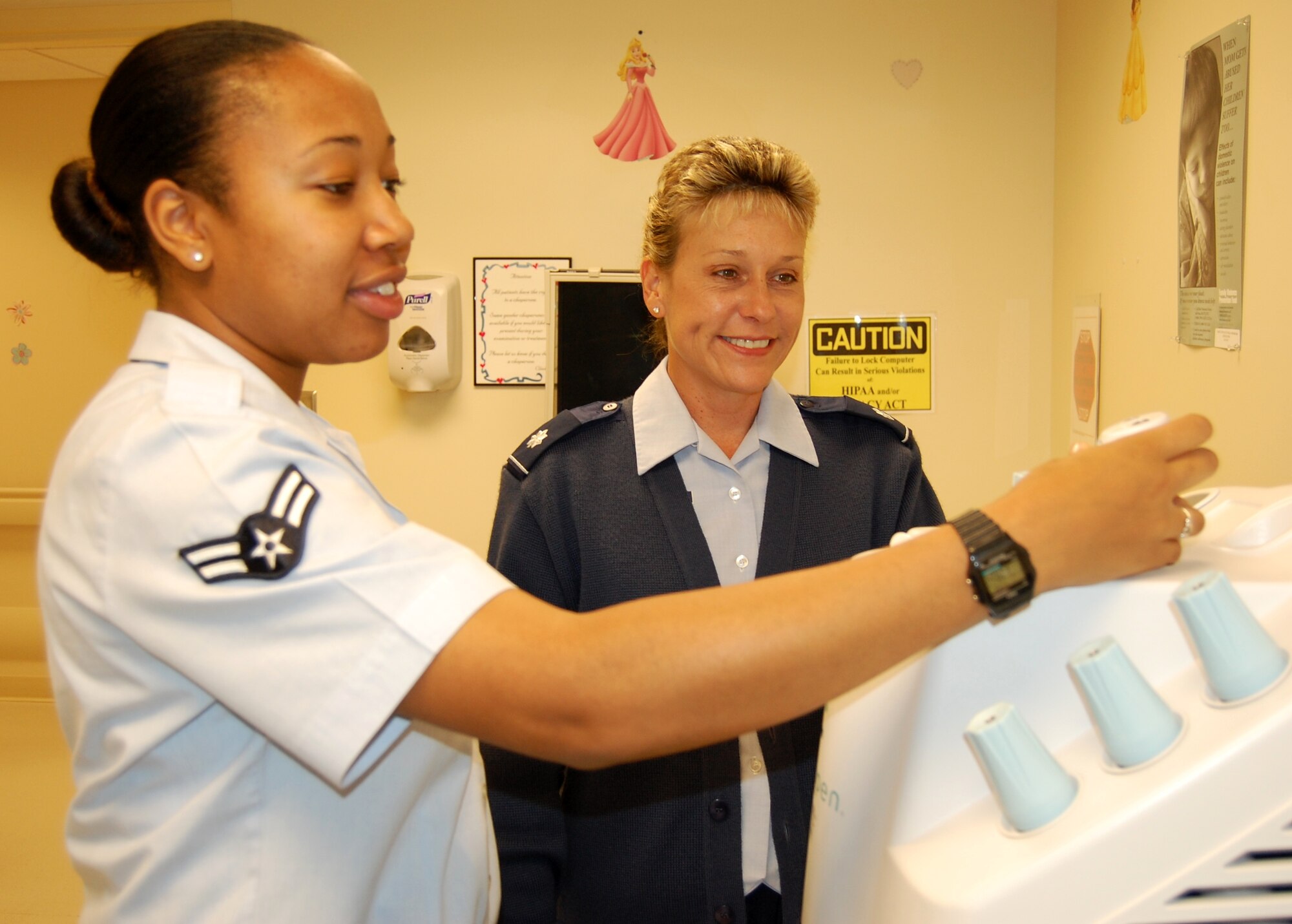 Airman 1st Class Rashawnda Eddings, left, a medical technician in the 81st Medical Operations Squadron’s pediatric clinic, shows her new commander, Lt. Col. Jane Denton, new Cryopen equipment used to freeze warts during Colonel Denton’s July 20 visit to the clinic.  Colonel Denton, who’s been selected for promotion to colonel, assumed command from Col. (Dr.) Kathleen Elmer June 22.   Colonel Elmer remains on staff as a dermatologist. The 81st MDOS has more than 400 medical professionals in the pediatric, medicine services, family health, emergency services, genetics, mental health and diagnostic imaging flights.   The colonel came to Keesler after completing Air War College at Maxwell Air Force Base, Ala.   Previously, she commanded the 14th MDOS and served as officer-in-charge of education and training, chief nurse executive and deputy commander of the 14th Medical Group, Columbus AFB, Miss.  (U.S. Air Force photo by Steve Pivnick)
