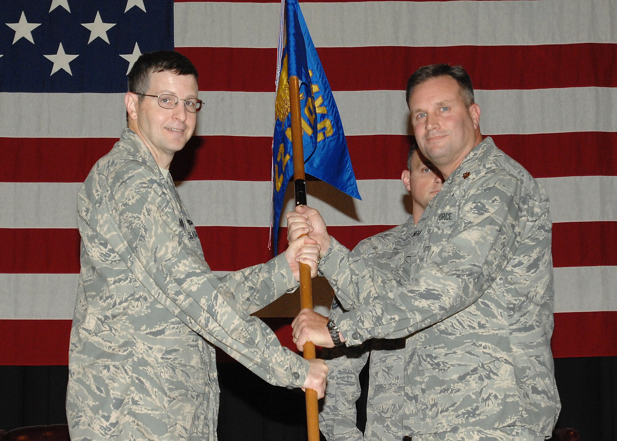 MCCONNELL AIR FORCE BASE, Kan. -- Col. Michael Novotny, 22nd Maintenance Group deputy commander, passes the 22nd Maintenance Operation Squadron guidon to Maj. Christopher Hague, giving him command of the squadron during an assumption of command ceremony, July 17. (Photo by Staff Sgt. Jamie Train)