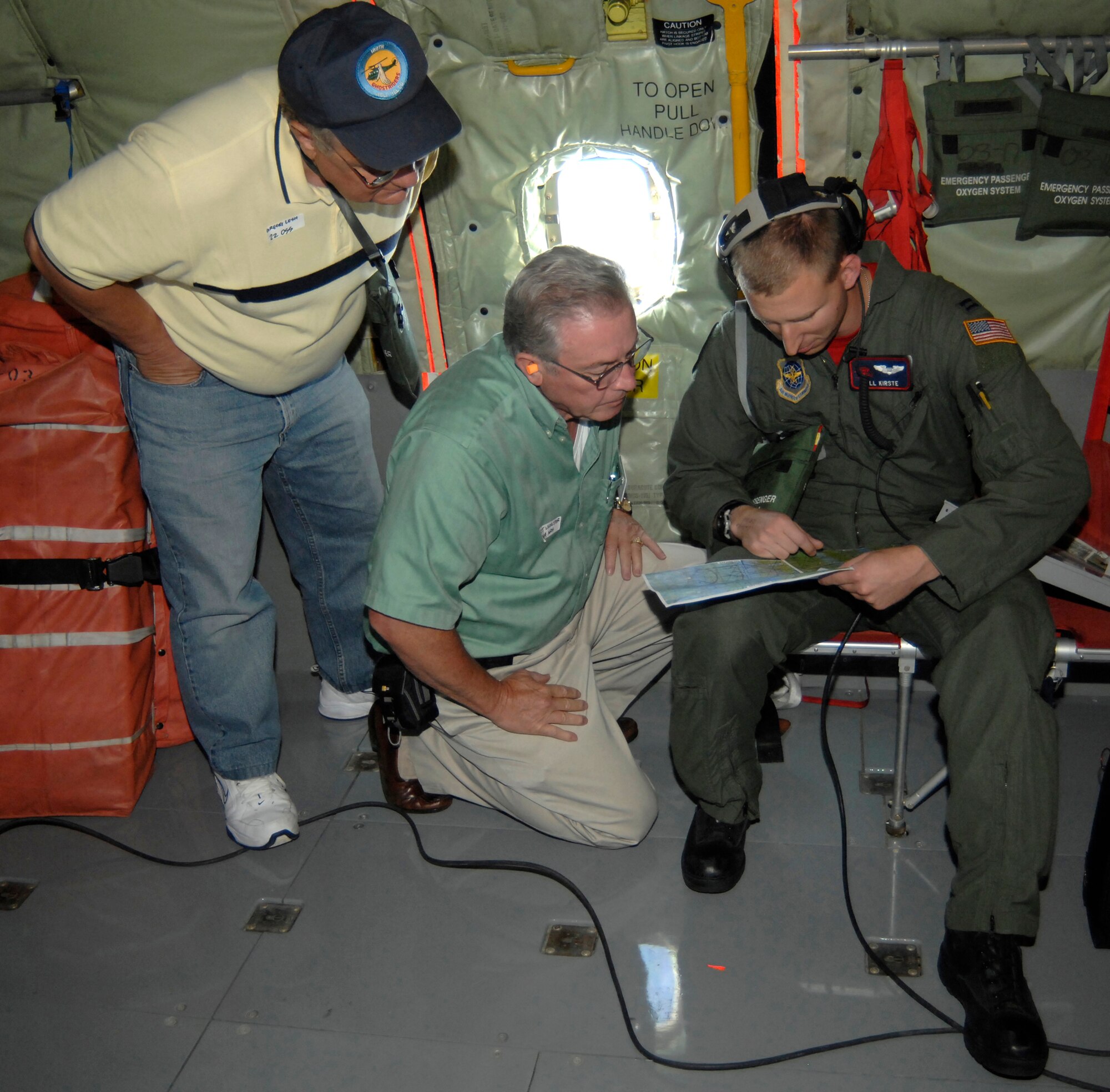 MCCONNELL AIR FORCE BASE, Kan. -- 1st Lt. Willard Kirste, 350th Air Refueling Squadron navigator, points on a map showing Gregg Lesh, 22nd Operation Support Squadron honorary commander, and O.J. Lichlyter, 384th Air Refueling Squadron honorary commander, the location they are flying over in a KC-135 Stratotanker, July 17. The seven honorary commanders participated on the flight for a refueling mission demonstrating McConnell’s air refueling capabilities. (Photo by Senior Airman Laura Suttles)
