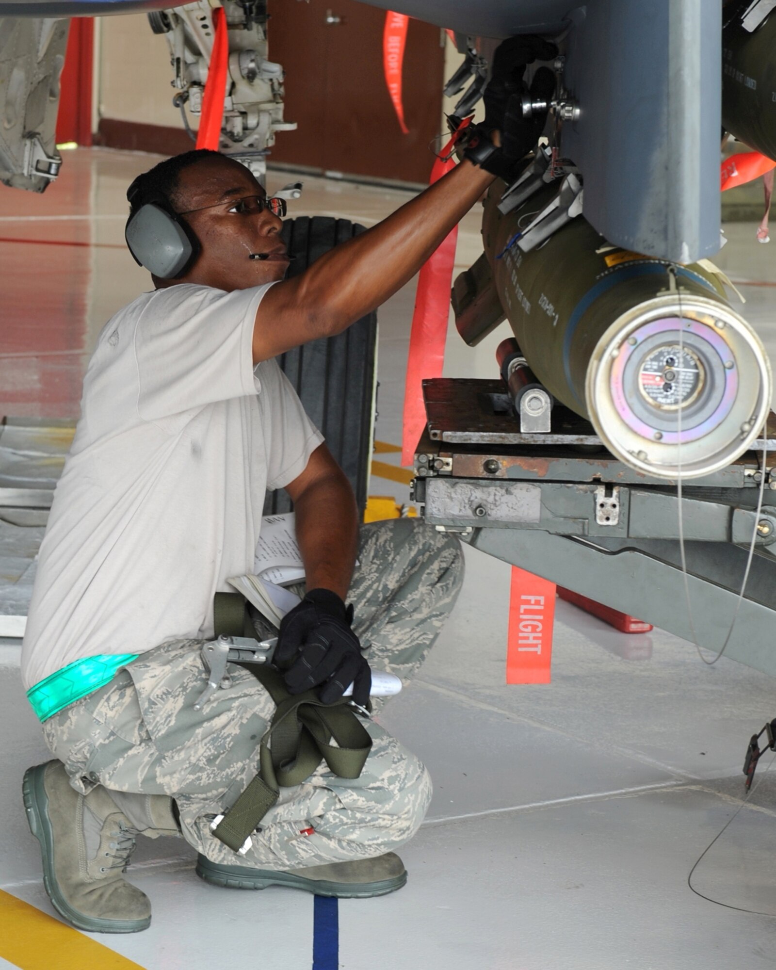 Staff Sgt. Ray Saunders, 335th Aircraft Maintenance Unit weapons load crew chief, locks a practice bomb to an F-15E Strike Eagle during a load crew competition on Seymour Johnson AFB, N.C., July 17, 2009. Sergeant Saunders has five years experience and training in loading munitions onto aircraft. (U.S. Air Force photo by Airman 1st Class Whitney S. Lambert)