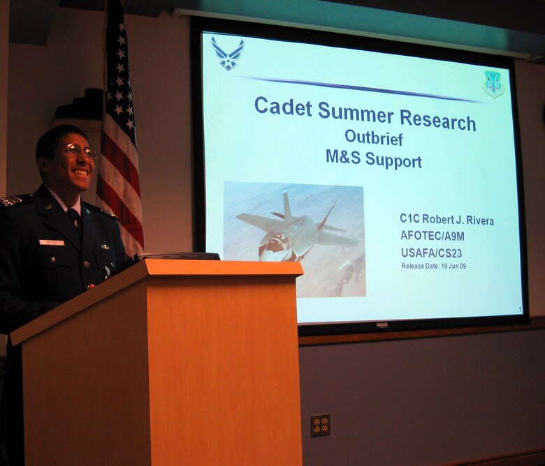 Cadet First Class Robert Rivera delivers his outbrief to Air Force Operational Test and Evaluation Center personnel at Kirtland Air Force Base, N.M., at the conclusion of his participation in the five-week U.S. Air Force Academy Cadet Summer Research Program. Cadet Rivera worked on modeling and simulation verification, validation, and accreditation with AFOTEC’s Intelligence, Analyses, and Assessments Directorate analyst team. (U.S. Air Force photo).
