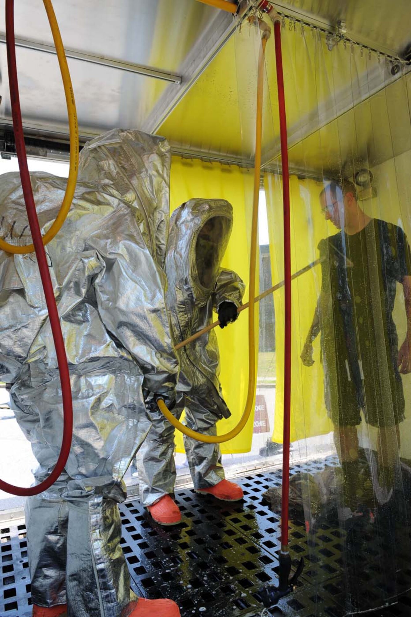 Airmen 1st Class Dustin Beckley and Christopher Sangle, 4th Civil Engineer Squadron firefighters, perform a simulated decontamination of Airman 1st Class Jesse Bennett, 4th Equipment Maintenance Squadron, during an all hazards response exercise on Seymour Johnson Air Force Base, N.C., July 15, 2009. The exercise trained emergency response teams to recognize and properly respond to different hazards during real life emergencies.  (U.S. Air Force photo by Airman 1st Class Gino Reyes)