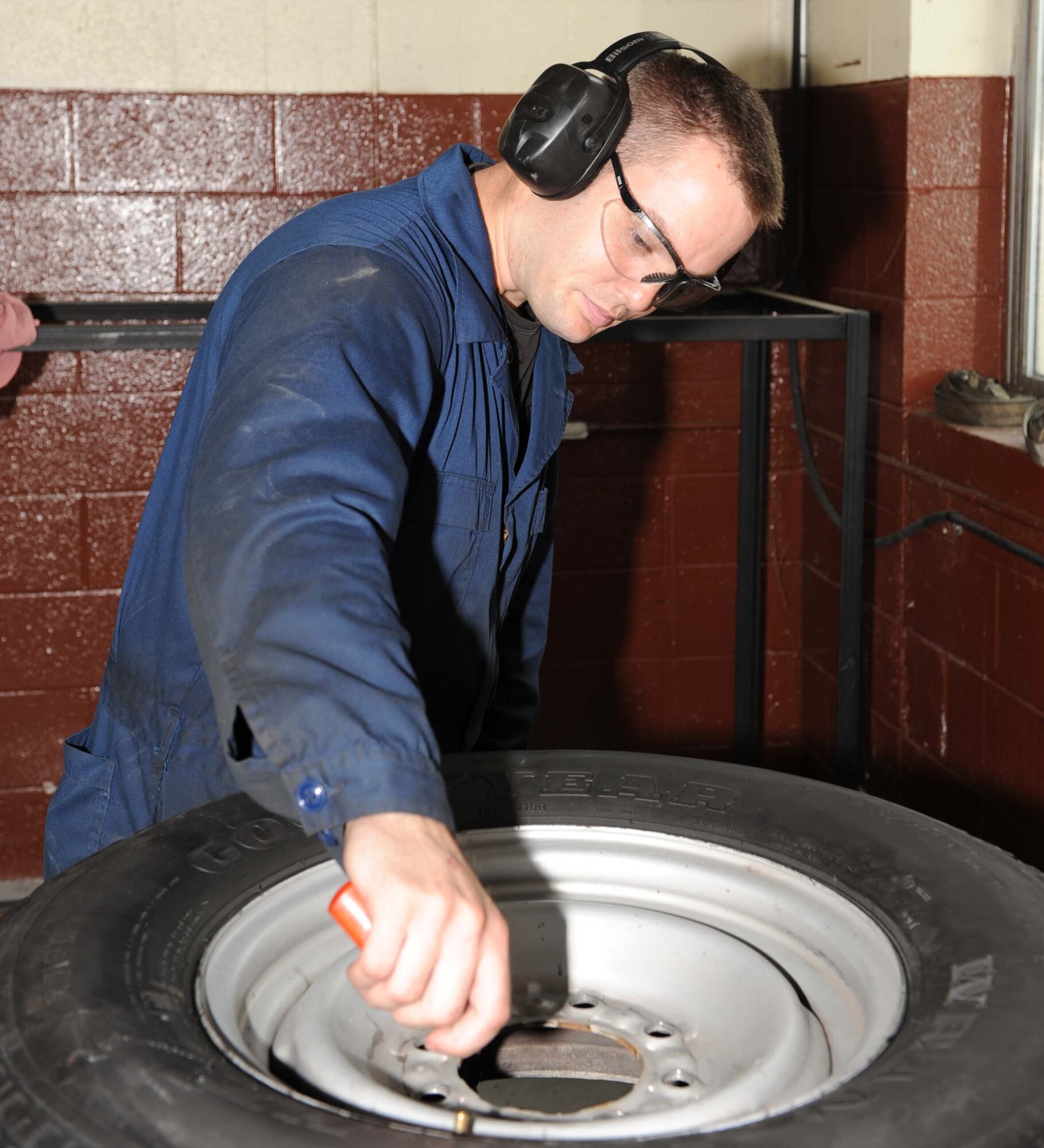 Senior Airman Brian May, 4th Logistics Readiness Squadron customer service technician, uses a small tire exchange machine on Seymour Johnson Air Force Base, N.C., July 20, 2009. Customer service is the starting and ending point for each government vehicle that comes in for repairs or scheduled maintenance. (U.S. Air Force photo by Airman 1st Class Gino Reyes)