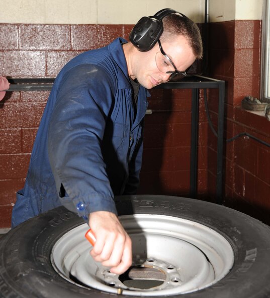 Senior Airman Brian May, 4th Logistics Readiness Squadron customer service technician, uses a small tire exchange machine on Seymour Johnson Air Force Base, N.C., July 20, 2009. Customer service is the starting and ending point for each government vehicle that comes in for repairs or scheduled maintenance. (U.S. Air Force photo by Airman 1st Class Gino Reyes)
