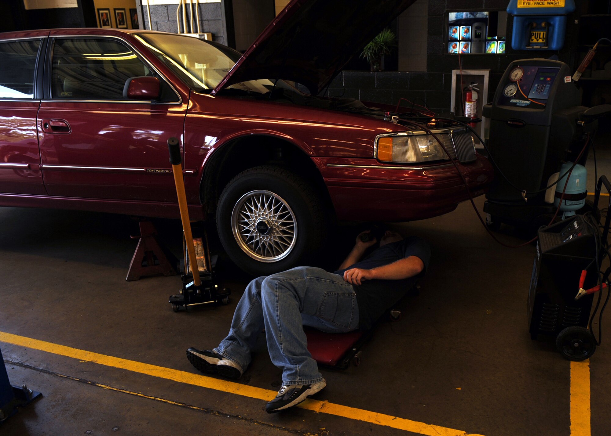 Army Sergeant J.R. Matthews checks his car for leaks and wear and tear at the auto hobby shop on Seymour Johnson Air Force Base, N.C., July 17, 2009. The auto hobby shop averages 490 cars a month and nearly 6,000 cars a year needing inspections, oil changes and other maintenance done. (U.S. Air Force photo by Senior Airman Ciara Wymbs)  