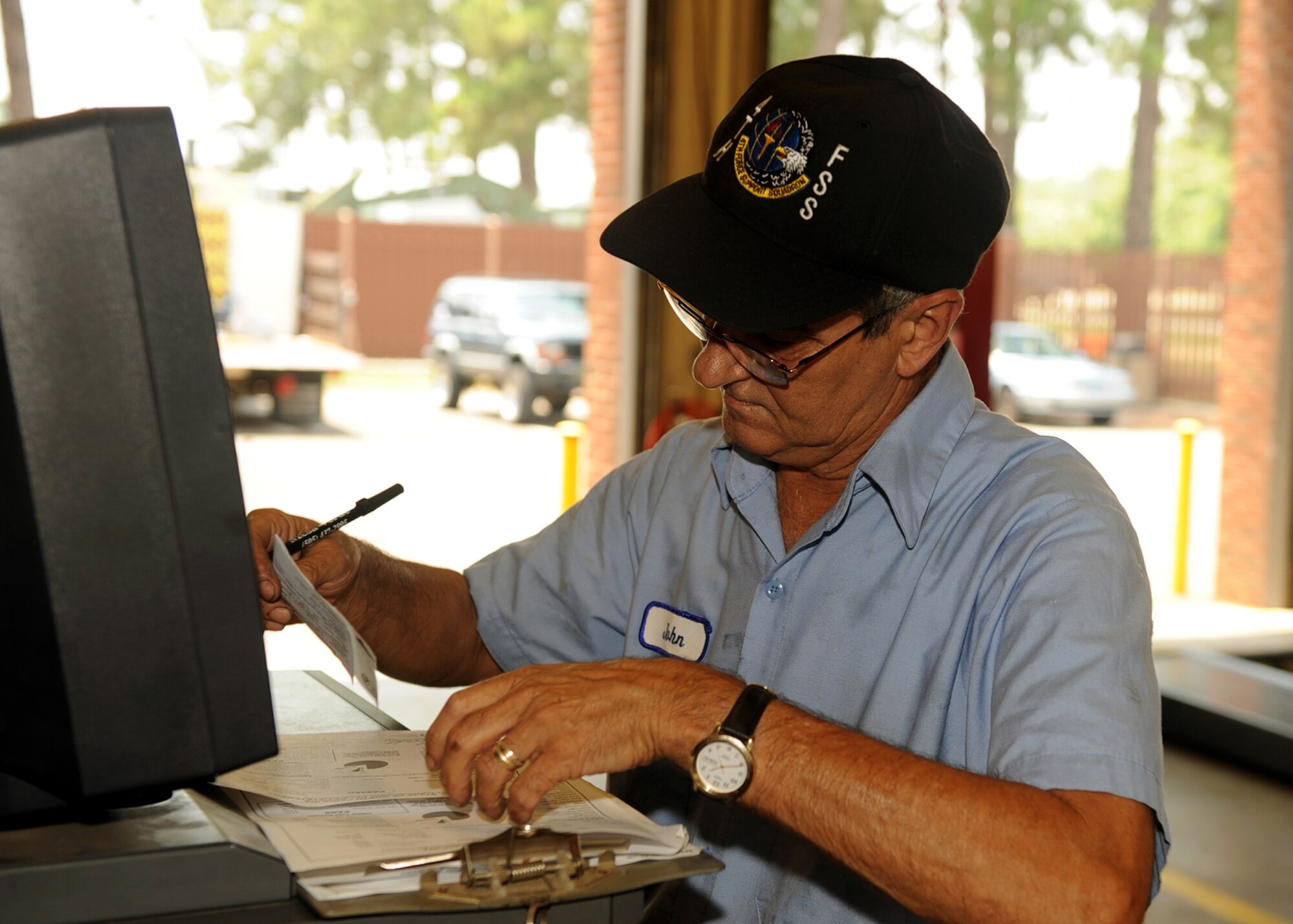 John Barnhart, an auto hobby shop mechanic, checks the registration and the inspection sheet for a vehicle on Seymour Johnson Air Force Base, N.C., July 17, 2009. Mr. Barnhart has worked at the auto hobby shop for six years and has worked on cars since he was 15 years old. (U.S. Air Force photo by Senior Airman Ciara Wymbs) 