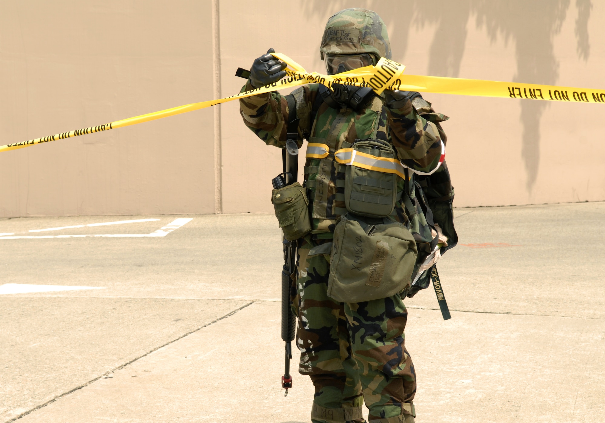 Tech. Sgt Edmundo Cruz ties together caution tape to make a cordon around a simulated unexploded ordinance during exercise Beverly Bulldog 09-03 at Osan Air Base, Republic of Korea.  Technical Sgt Cruz is a dental technician for the 51st Dental Squadron. (U.S. Air Force photo/Senior Airman Stephenie Wade)