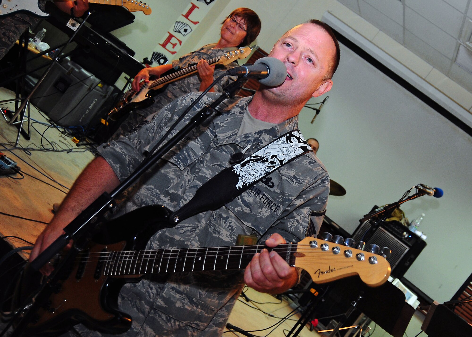 SOUTHWEST ASIA -- Sonora band member, Master Sgt. Michael Baker, deployed from the 141st Air Refueling Wing, Fairchild Air Force Base, Wash., plays guitar during the bands performace for the 386th Air Expeditonary Wing July 21. The band is finishing up a month-long tour throughout the region. (U.S. Air Force photo/Tony Tolley)