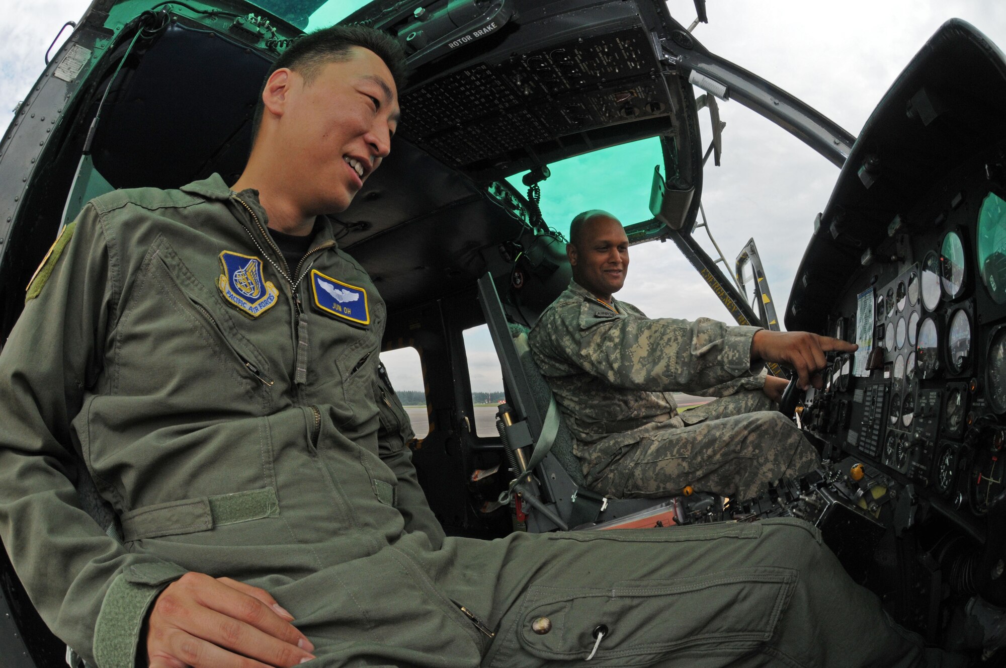 YOKOTA AIR BASE, Japan -- Army Warrant Officer Christopher Sebastian, 78th Aviation Company HH-60 Blackhawk maintenance test pilot (right), and Air Force Capt. Jun Oh, 459th Airlift Squadron UH-1N Huey pilot , view gauges in a Huey cockpit as part of a joint service training day July 17. Both the Air Force and Army play a crucial role in the airlift mission for the Pacific region. The 459th AS and 78th AC from Camp Zama, came together to share their expertise and information on local area flying techniques.  During the professional exchange the units learned about each other's regular flight routes, capabilities and experiences. (U.S. Air Force photo/ Staff Sgt. Veronica Pierce)  